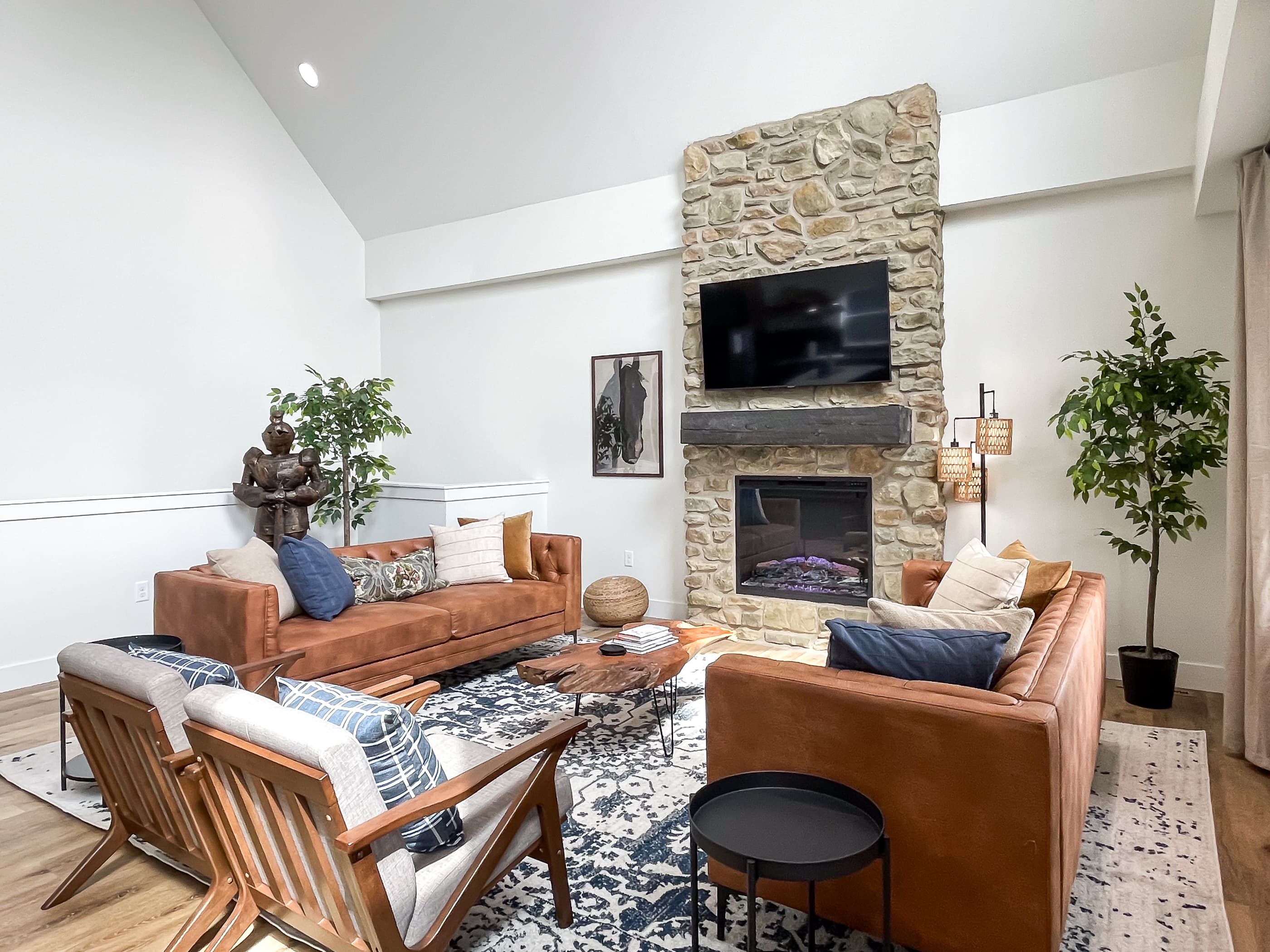 Cozy couch and chair seating in front of the electric fireplace, tv, and of course the suit of armor