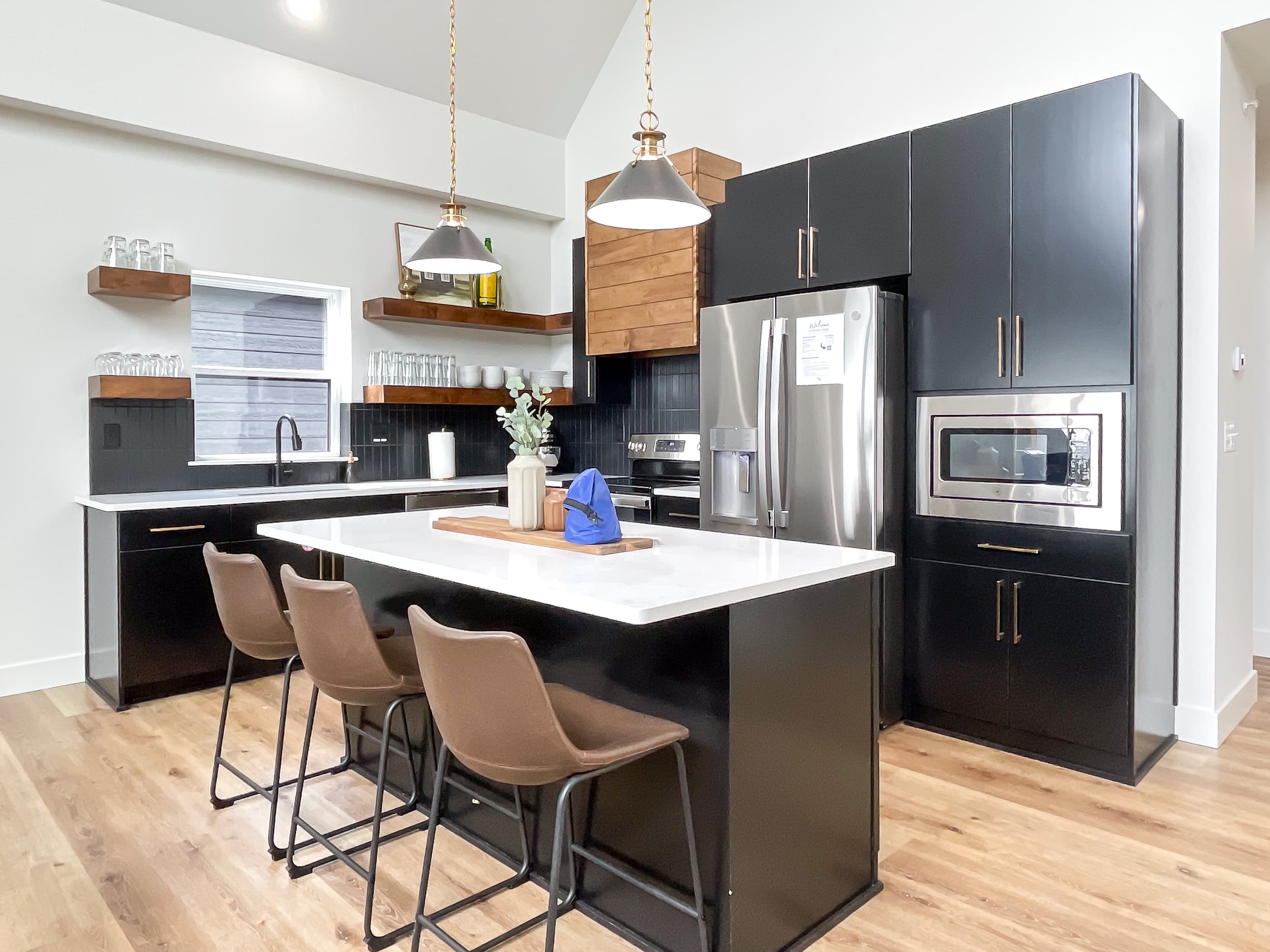 Full sized spacious kitchen with large island, breakfast bar, dishwasher, stove, refrigerator, and mircrowave