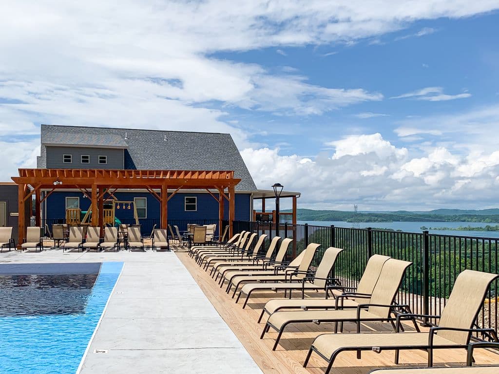 Neighborhood outdoor pool with playground and lake view