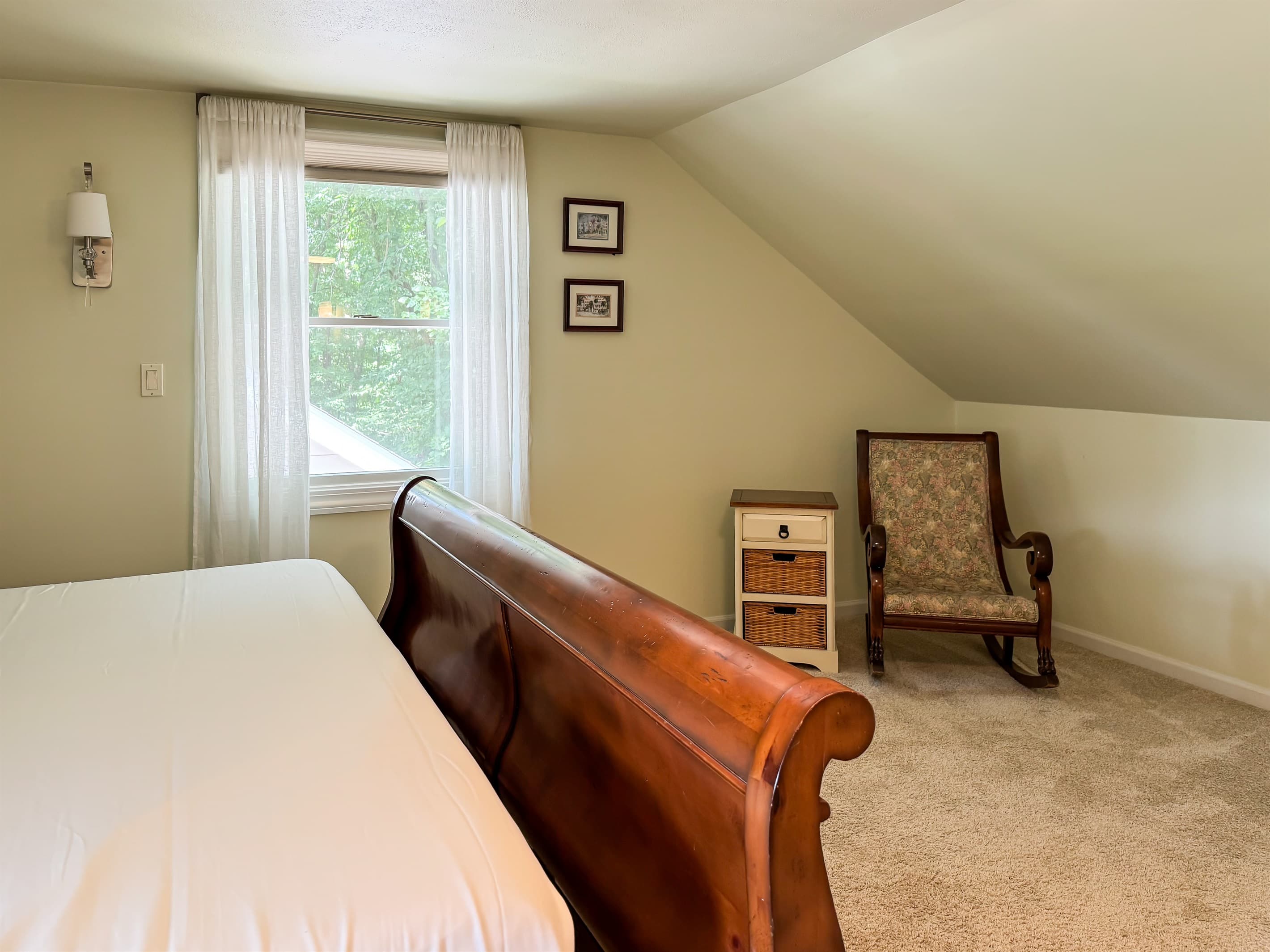 Spacious king size bedroom 3 (upper level) with crisp white linens, en suite bathroom and rocking chair for reading your favorite new book at Pointer Haus.