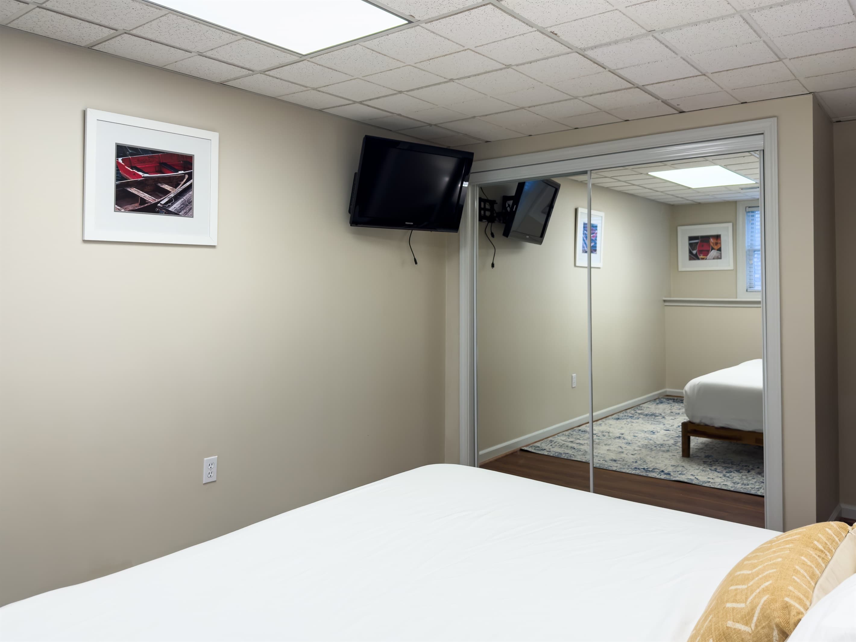 Spacious king size bedroom 2 (lower level) with crisp white linens, hall bathroom (tub/shower combo), large closet and smart TV at Pointer Haus.
