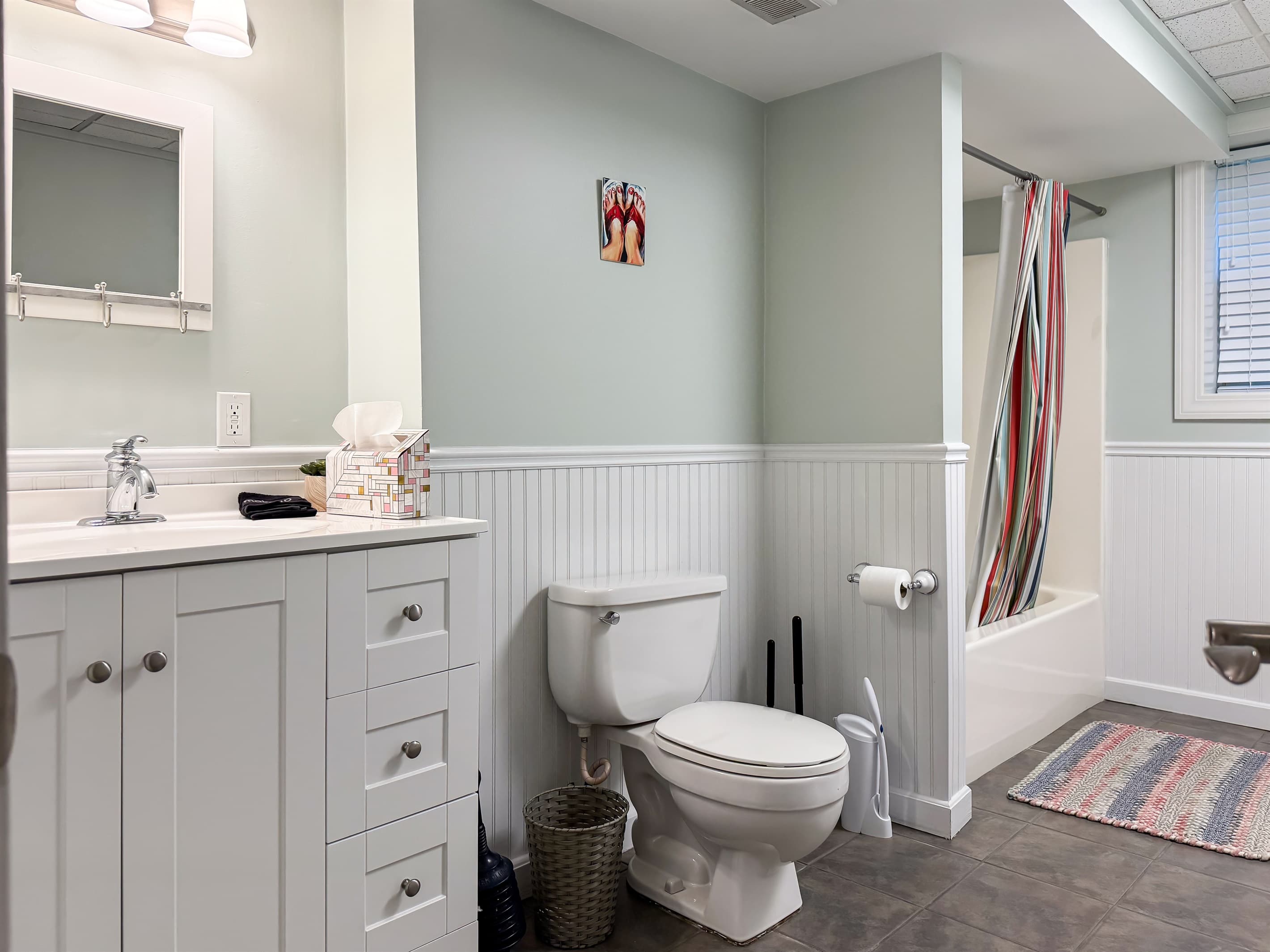 Spacious hallway bathroom (lower level) with tub/shower combo that includes fluffy white towels and shampoo/conditioner and a mini bar of handmade goat milk soap.