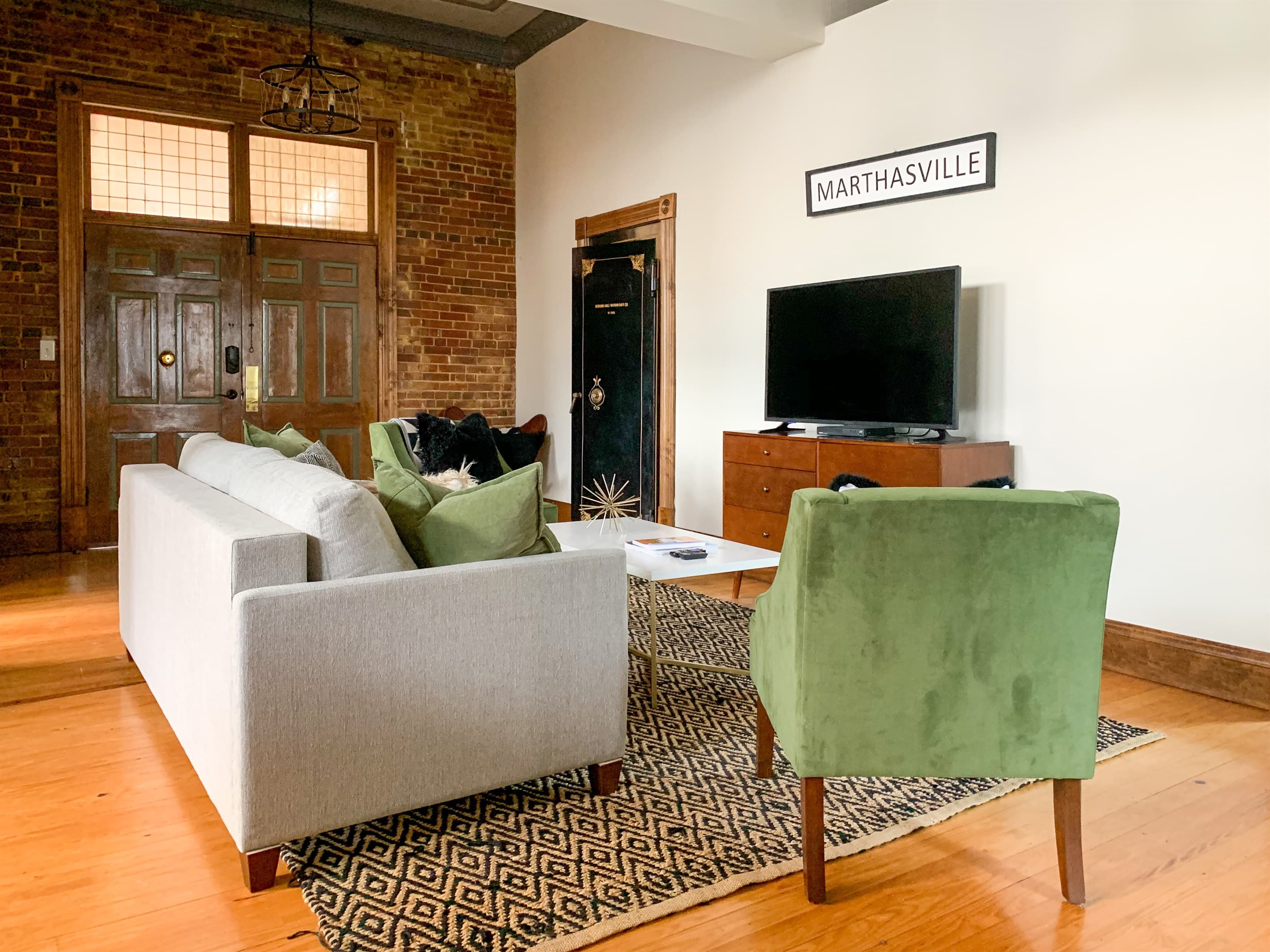 Spacious main level living area with king pull out bed and ample seating at the Bank Haus