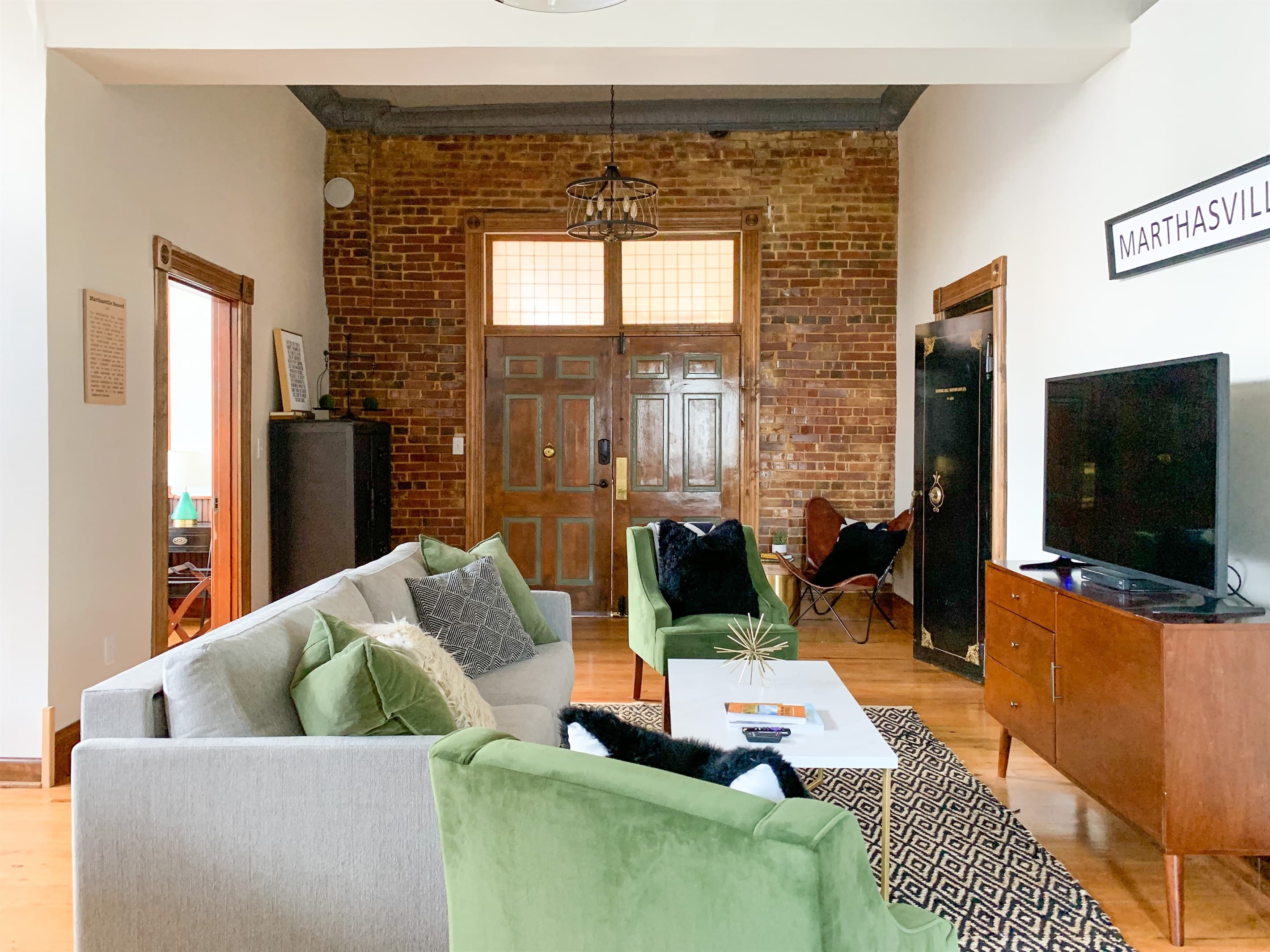 Spacious main level living area with king pull out bed, ample seating, and smart TV at the Bank Haus