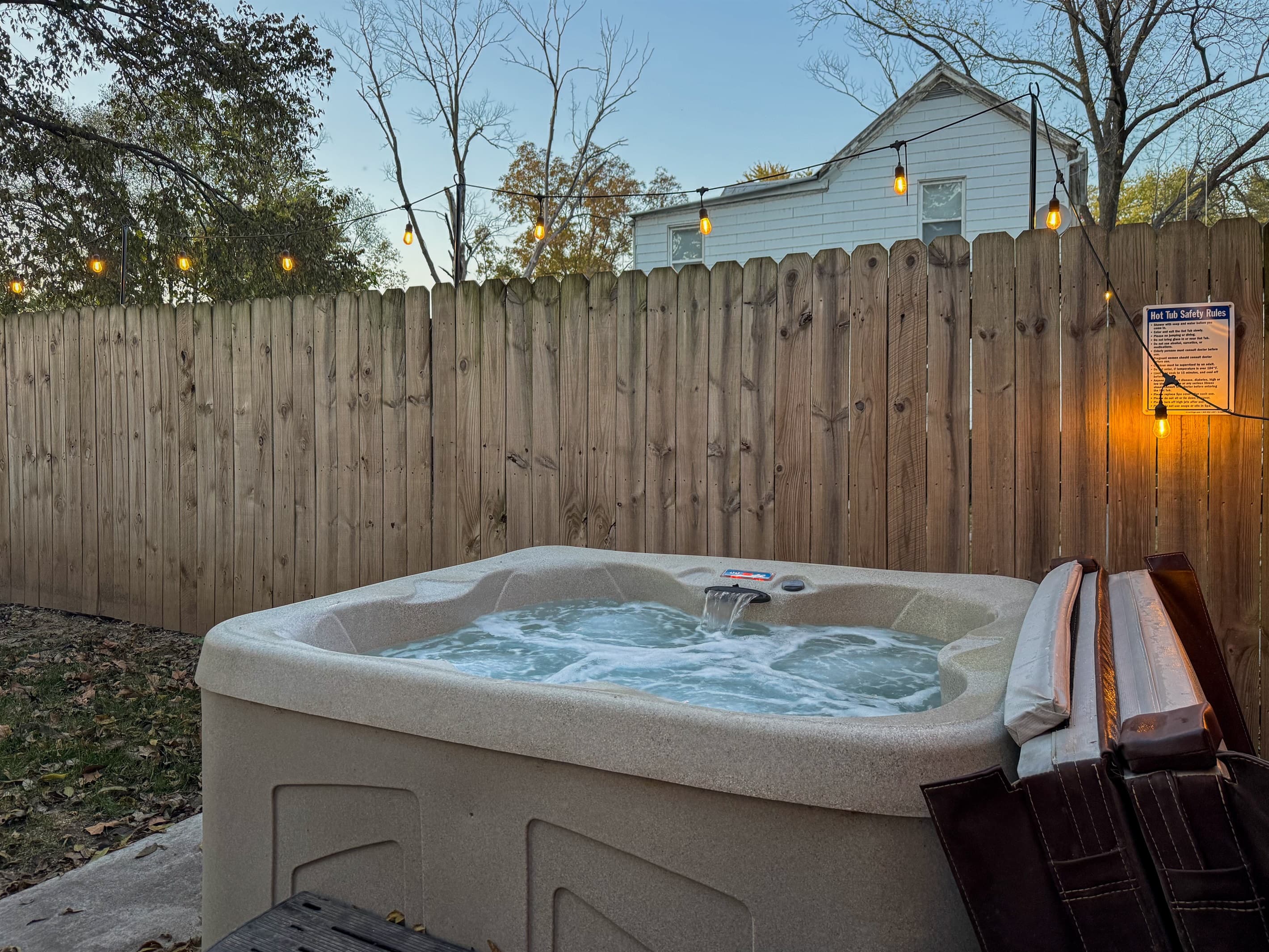 Private fenced in hot tub with twinkle lights at the Bank Haus