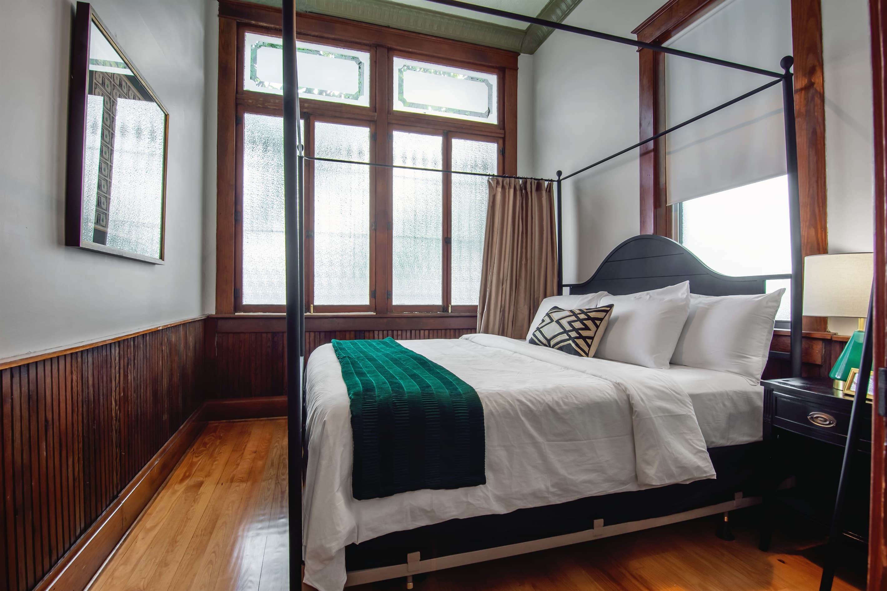 Main level bedroom with side table, luggage rack, clothing rack, and cozy king size bed.