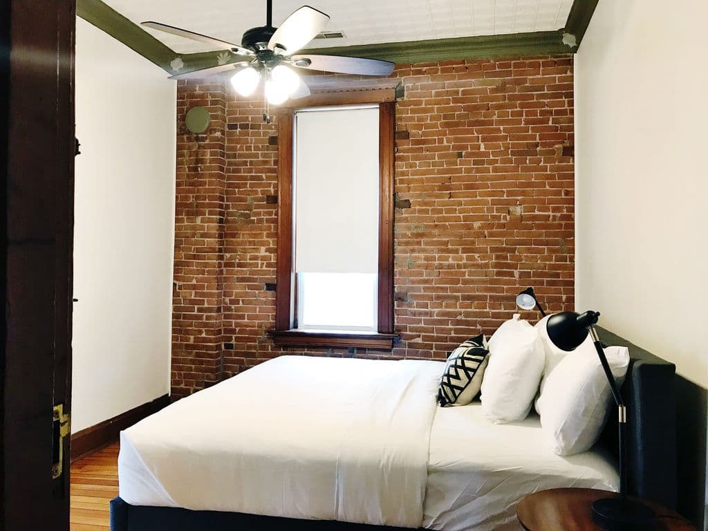 Upper level middle bedroom with king bed, luggage/clothing rack and ample room around the bed.