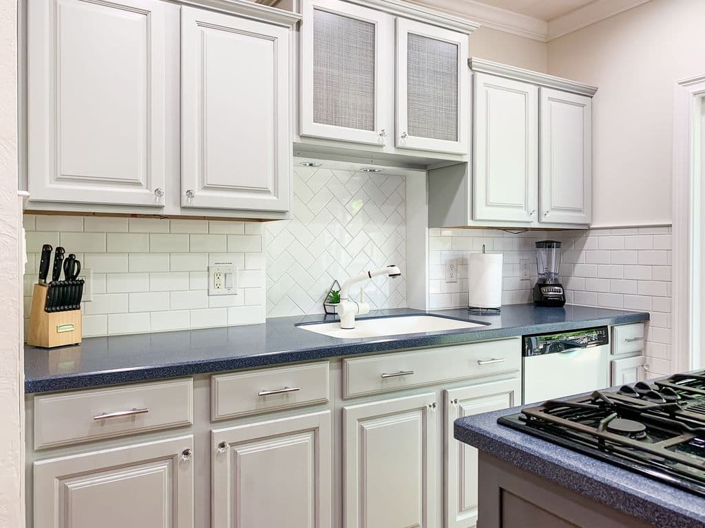 Bright and open kitchen with abundant counter space, cooking tools, dishwater and appliances.