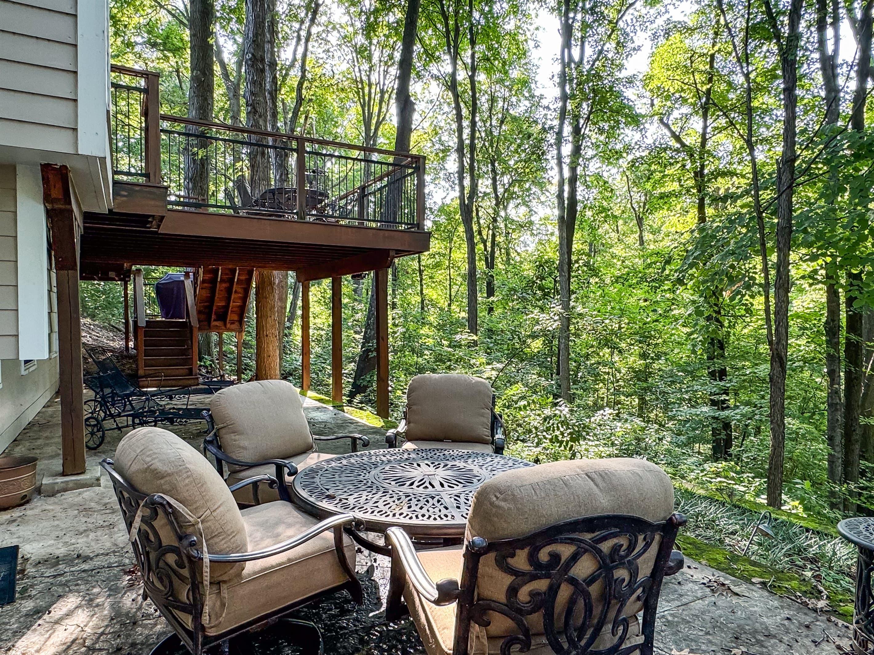 Lower back porch with an outdoor comfy table and chairs for enjoying the secluded backyard at Pointer Haus