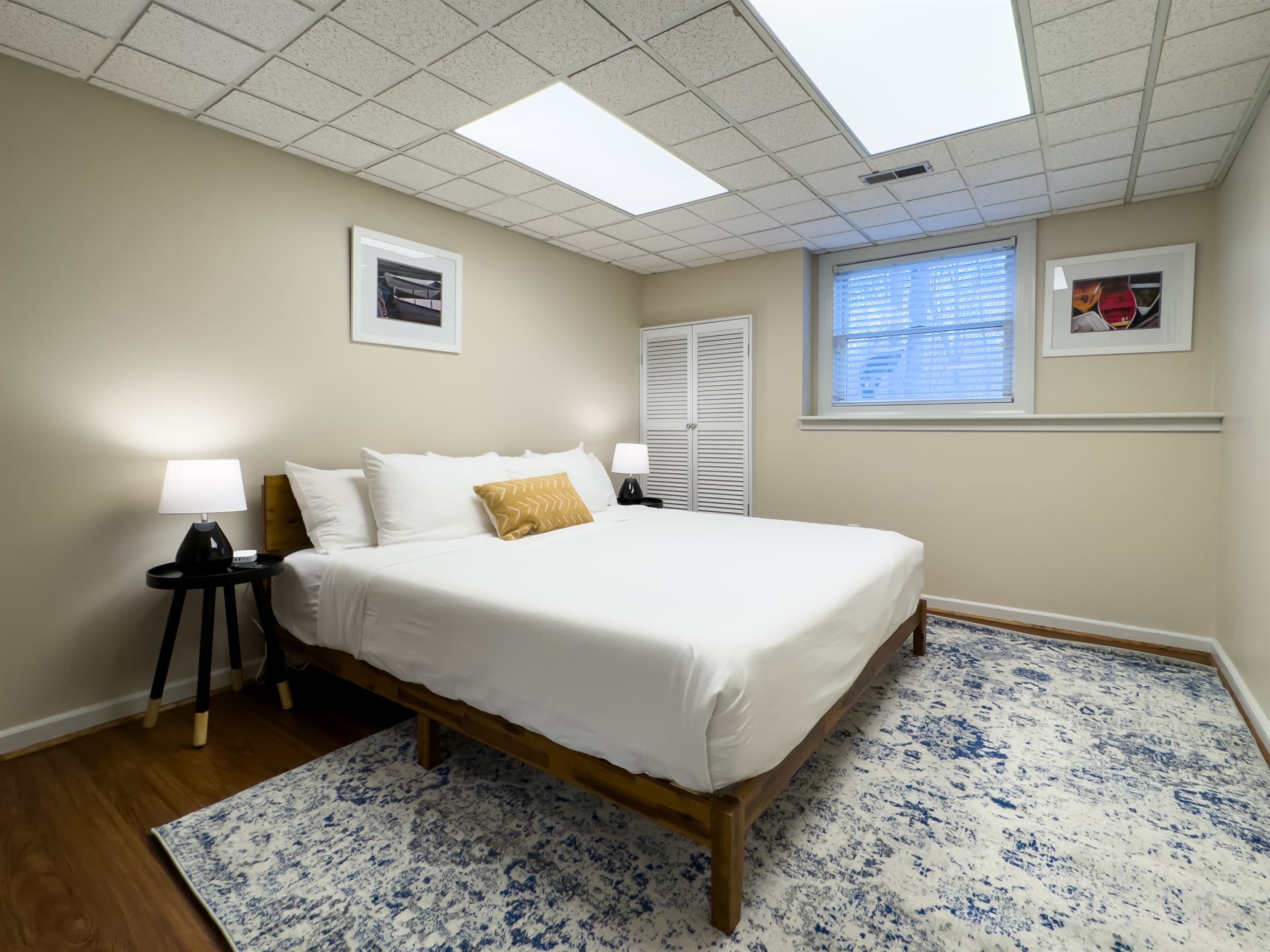 Spacious king size bedroom 2 (lower level) with crisp white linens and hall bathroom (tub/shower combo) at Pointer Haus.