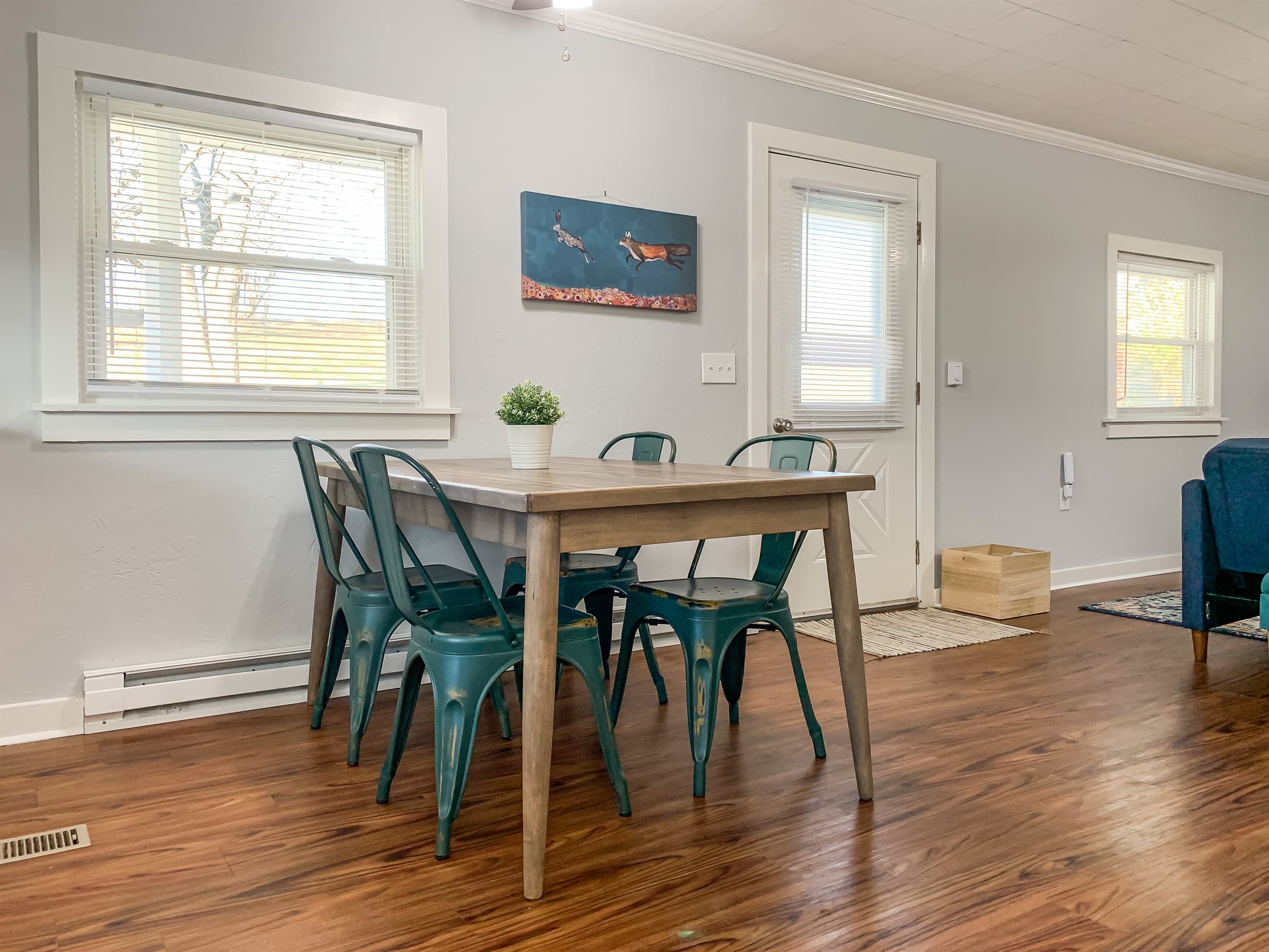 Sturdy dining table and chairs for four and entry door to inviting front porch at the Fox Haus.