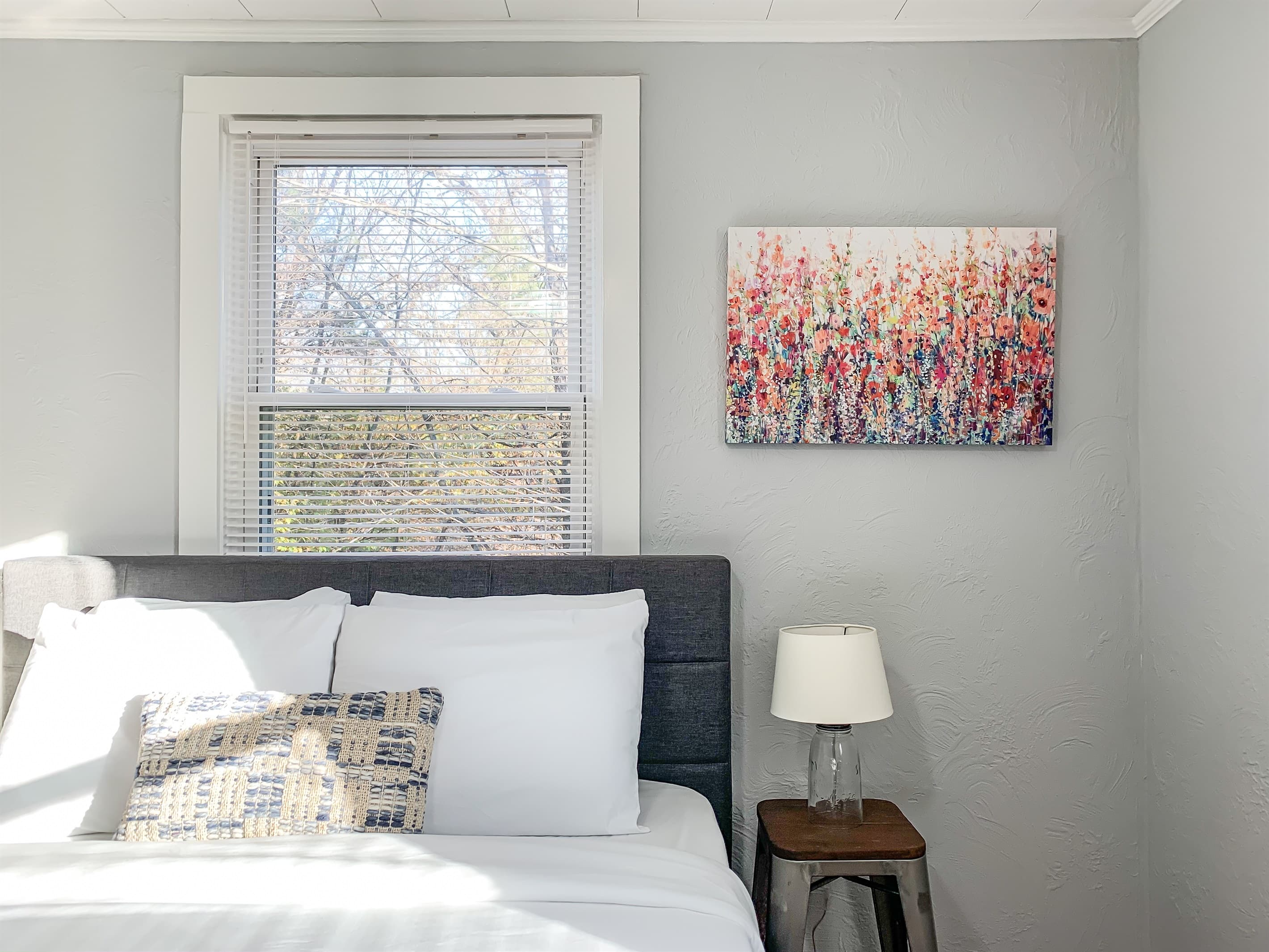 Cozy queen bed with side table and lamp at the Fox Haus.