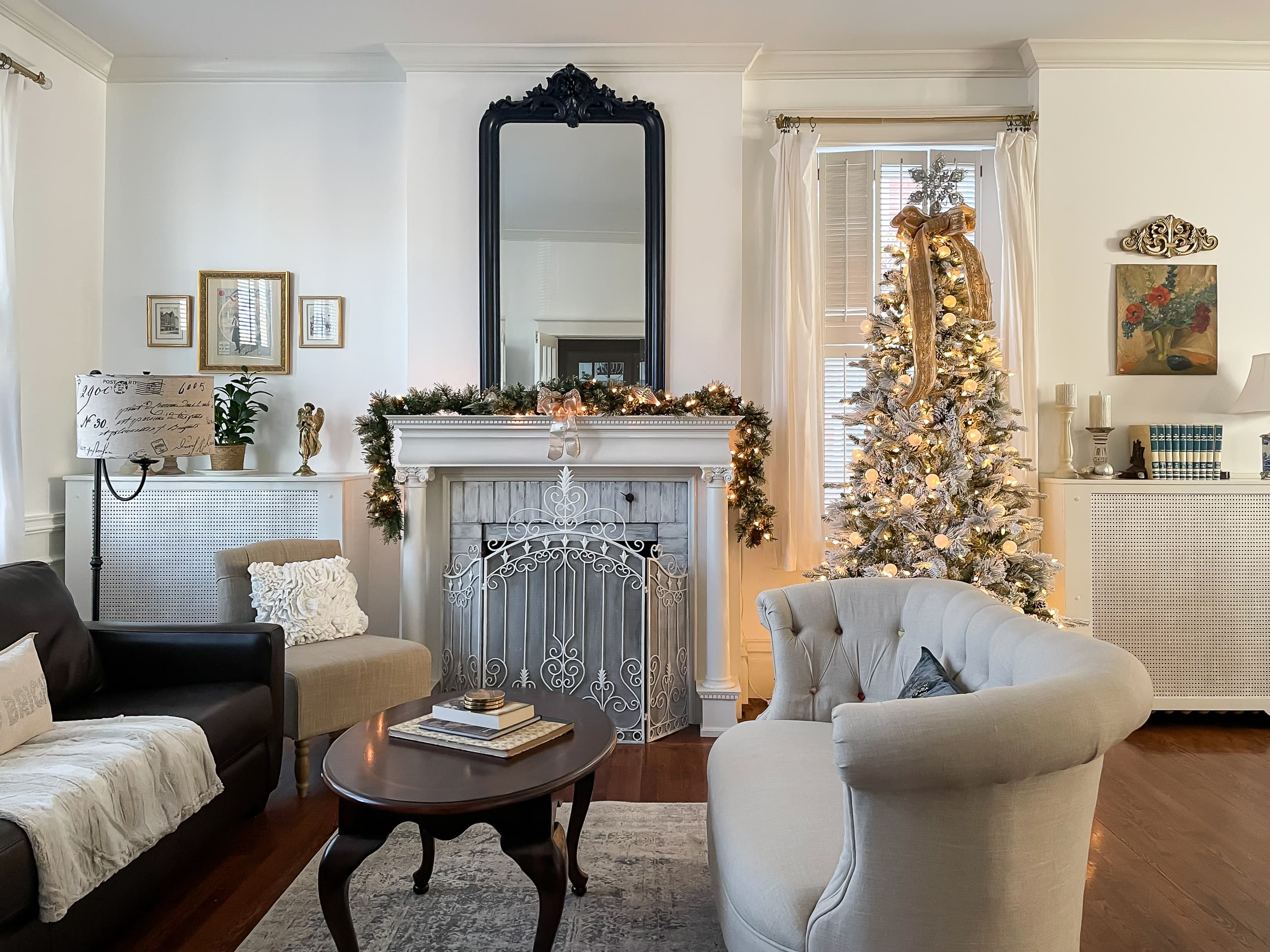 The living area on the main level at Mill Haus is an open floor plan stretching the entire side of the house, showcasing the tall ceilings, old fireplace and hardwood floors and beautifully decorated for the holidays.