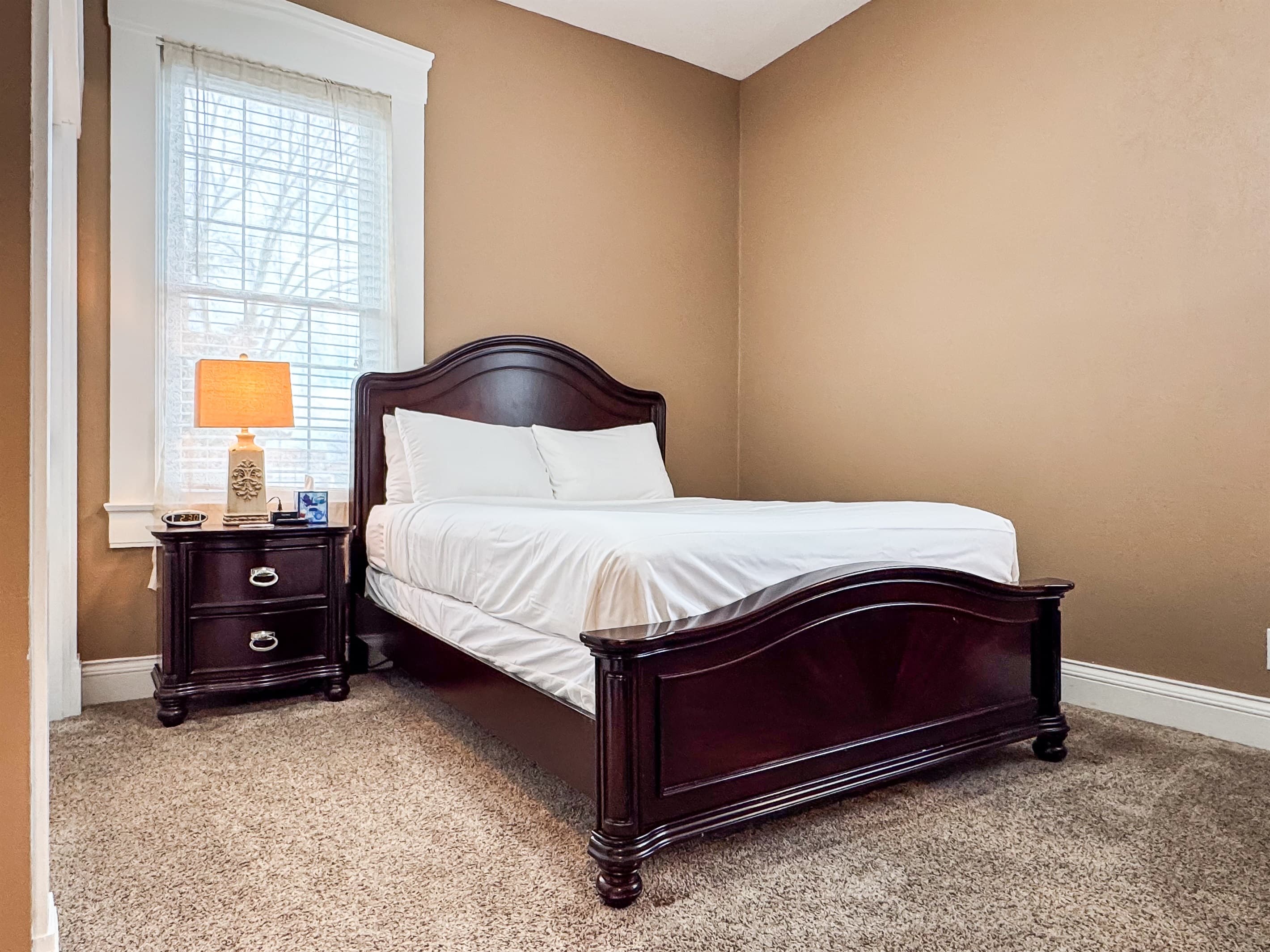 Spacious main level plush queen size bedroom with crisp white linens and full bathroom with combo tub and shower off the hallway at Aussie Cottage.