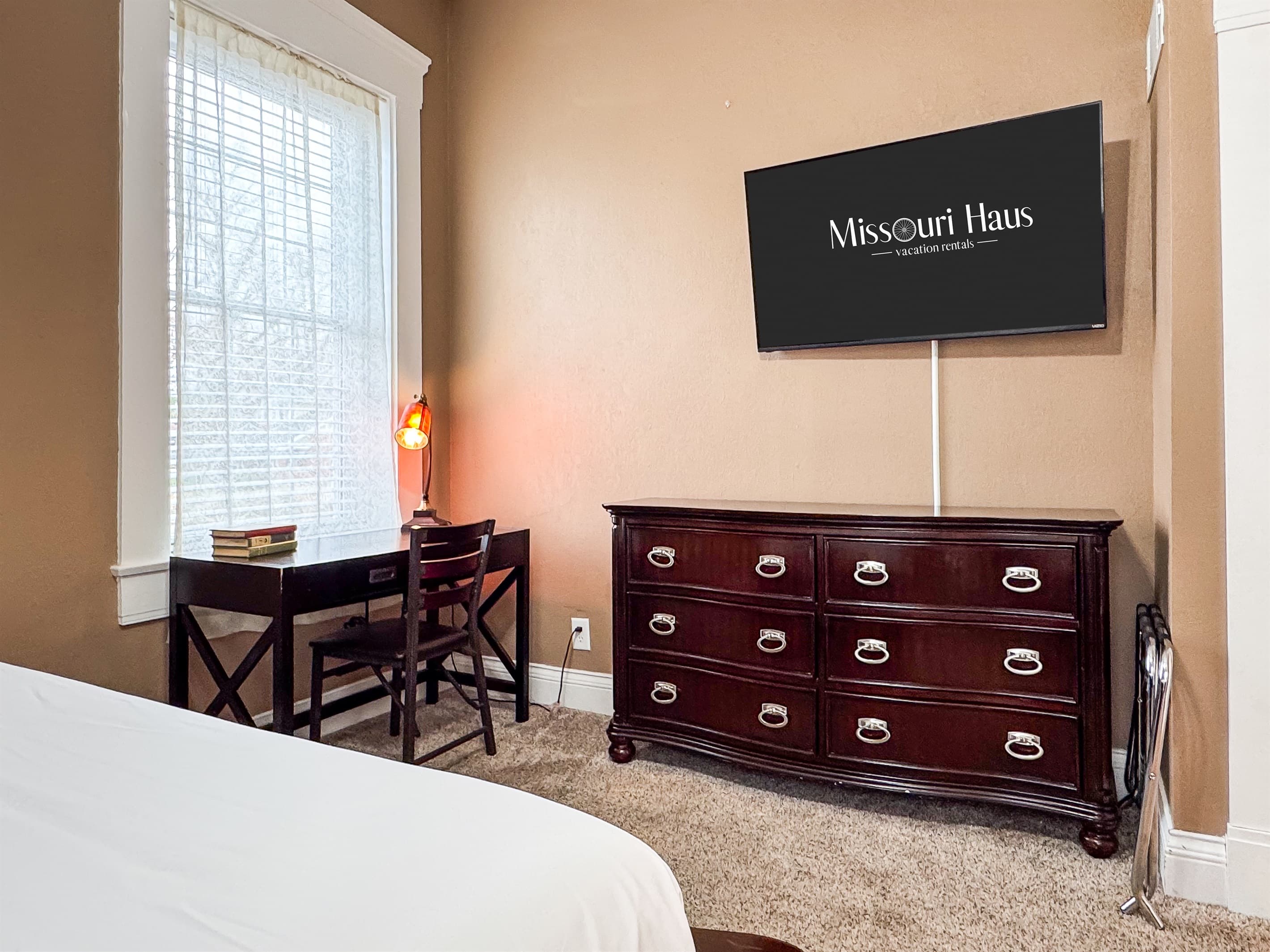 Spacious main level plush queen size bedroom with flat screen TV and full bathroom with combo tub and shower off the hallway at Aussie Cottage.