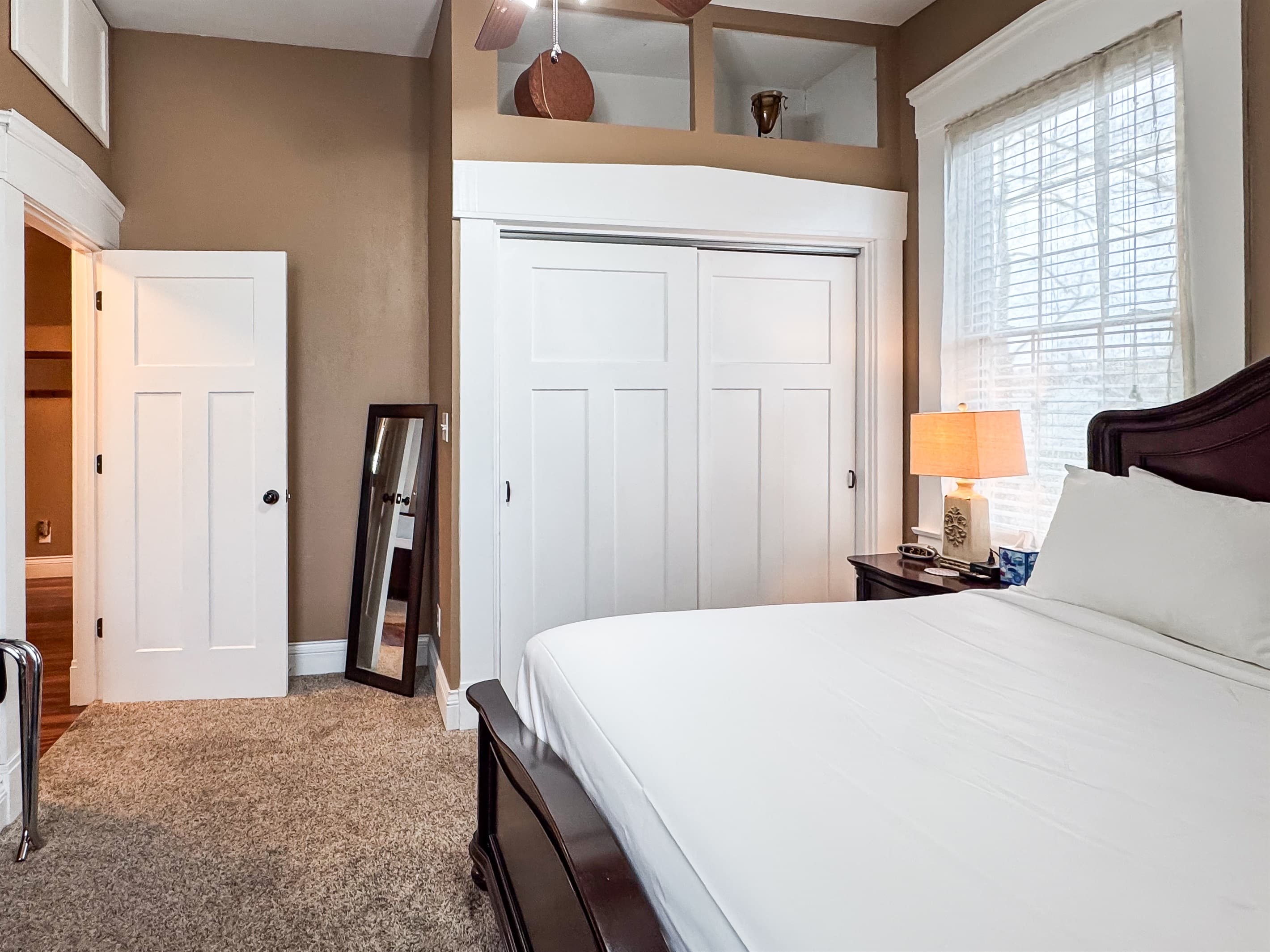 Spacious main level plush queen size bed with crisp white linens and full bathroom with combo tub and shower off the hallway at Aussie Cottage.