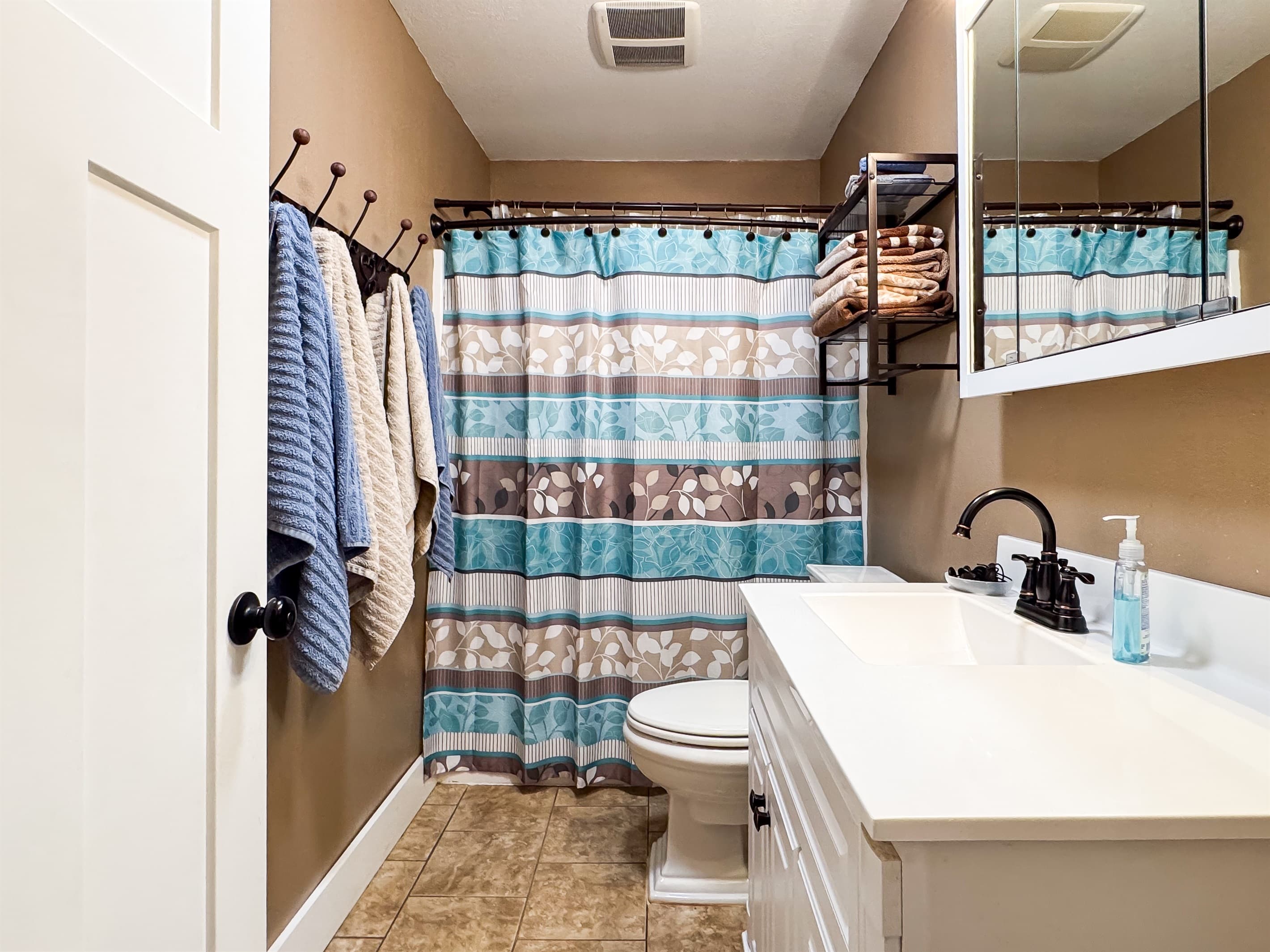 Modern main level full bathroom with combo tub and shower in the hallway at Aussie Cottage.