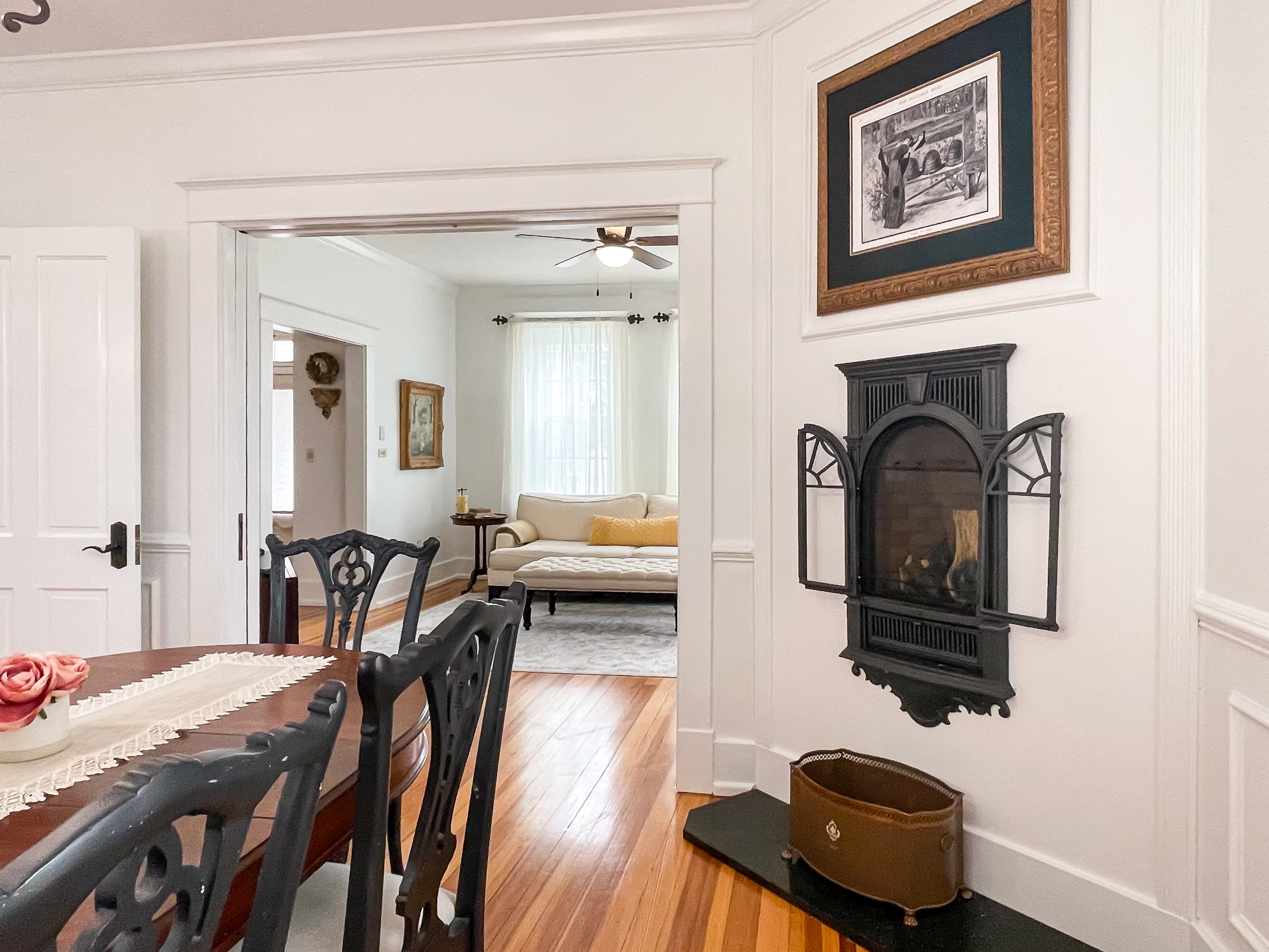The large dining area showcasing a century old fireplace includes a gorgeous hardwood dining table and seating for 6 people for family dinners or game night at The Beekeeper's Cottage.