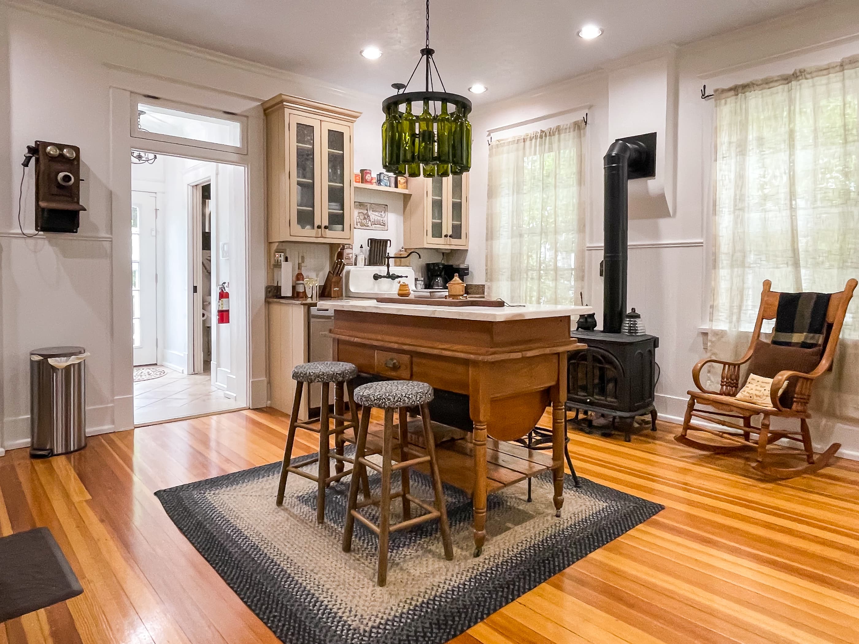 The beautifully detailed full kitchen with modern amenities to enjoy prepping meals for your family/coworkers/friends and eclectic lighting made from wine bottles at The Beekeeper' Cottage.