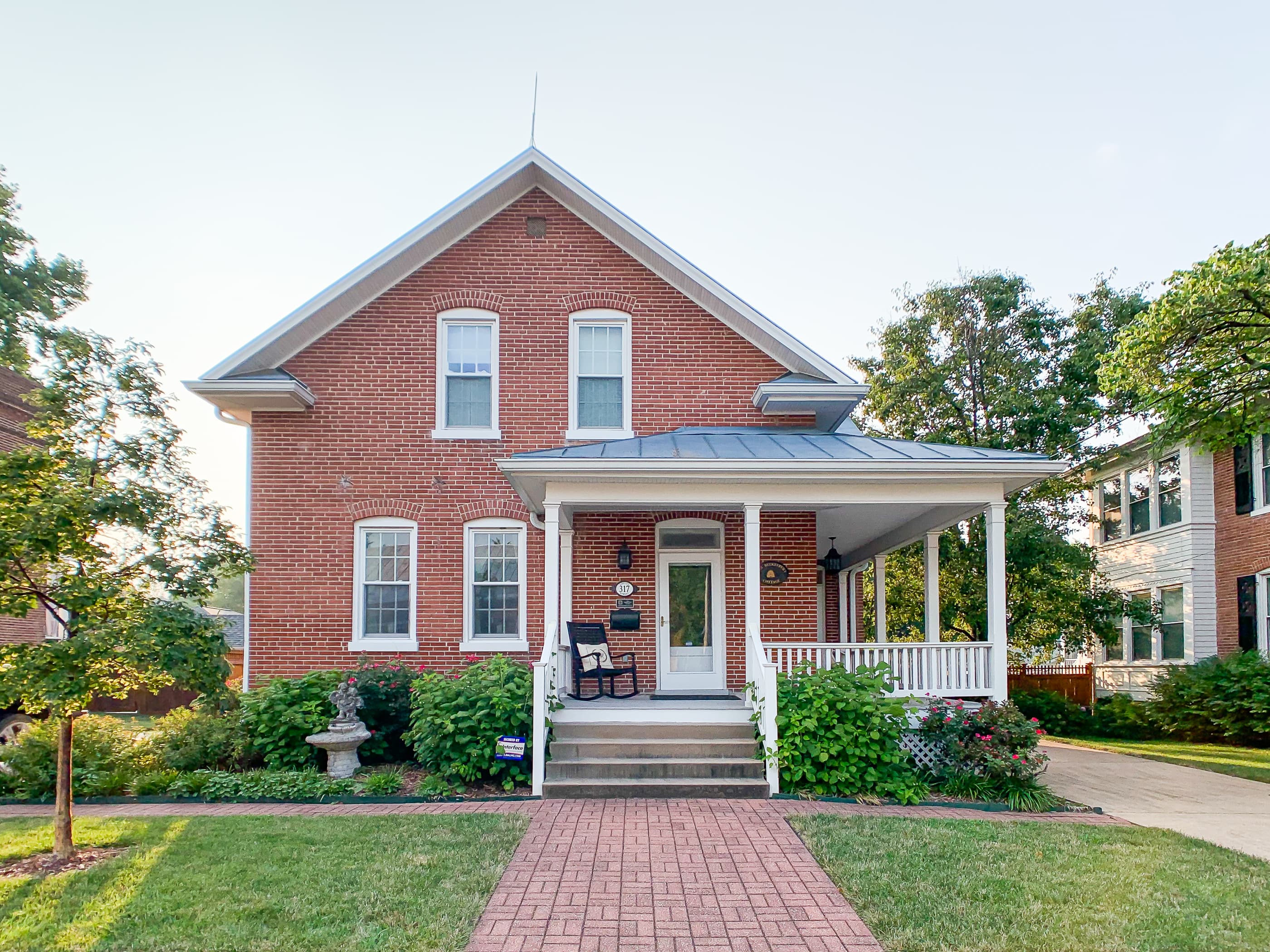 The historic Beekeeper's Cottage features a veranda style front porch that wraps around the side and provides additional open living space to enjoy the outdoors.
