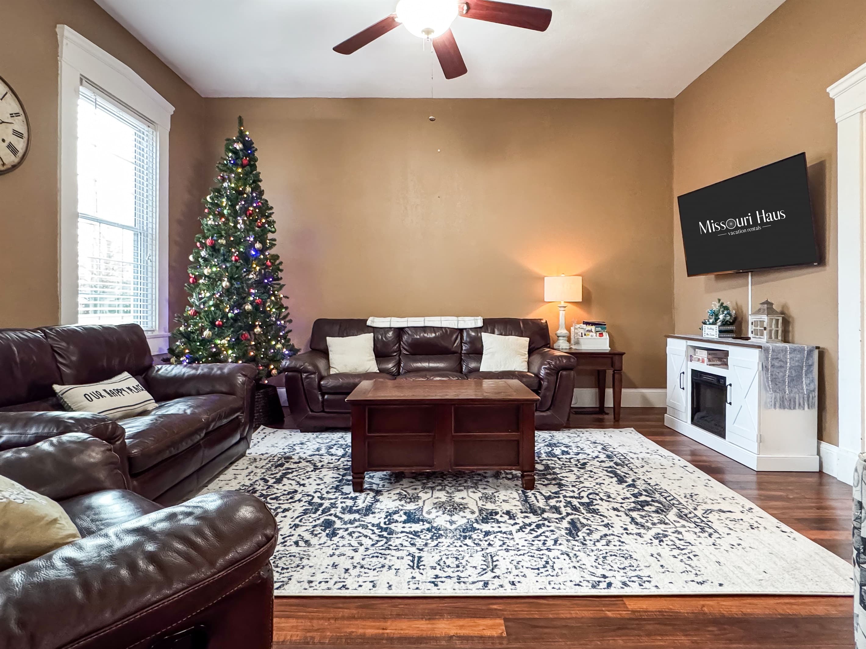 Warm and inviting Great Room with comfy leather couch, loveseat and recliner and Flat Screen Smart TV just off the kitchen for a perfect setup for families/groups to relax and reconnect during the holiday at Aussie Cottage.
