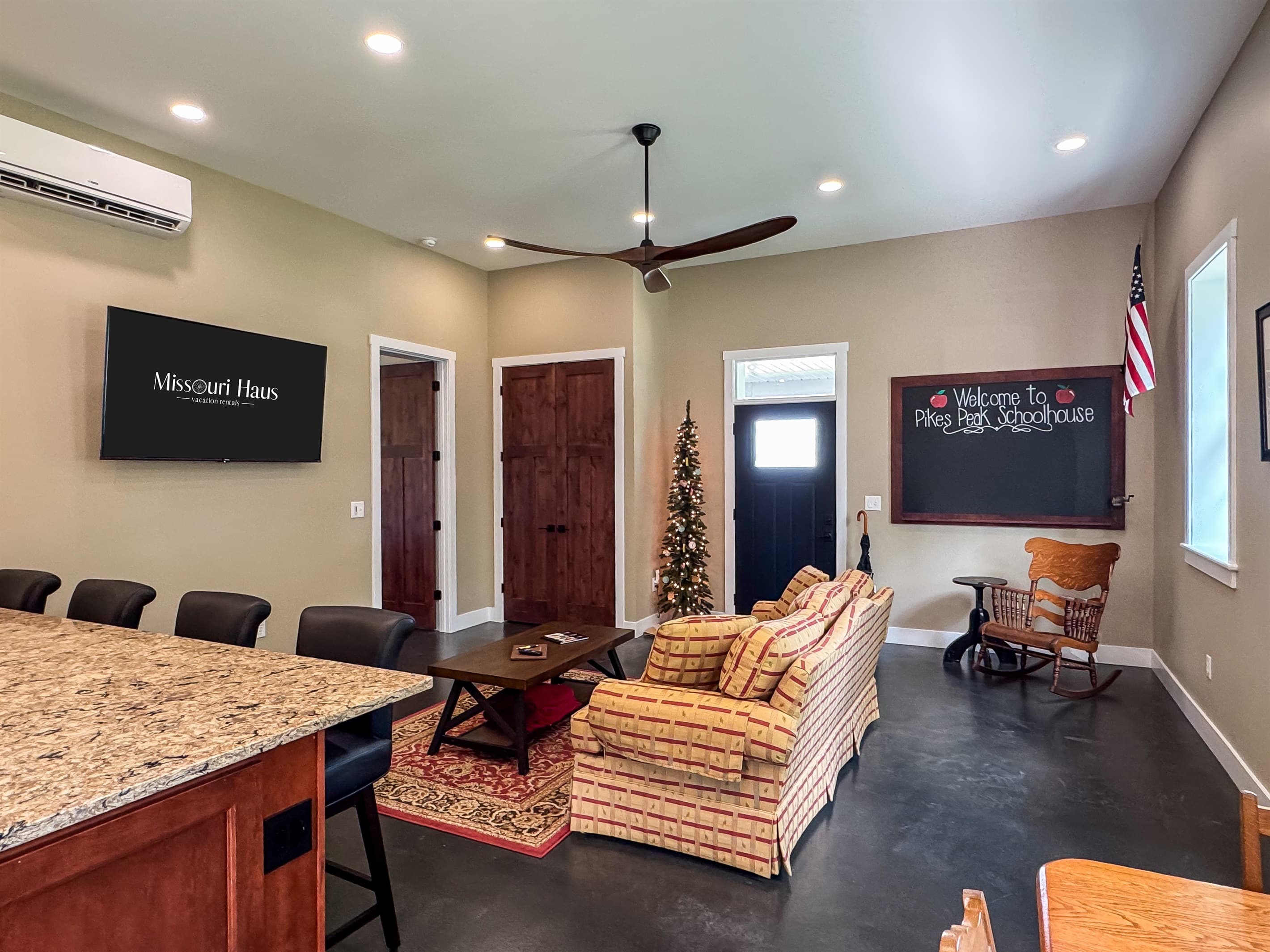Main living area with smart tv, open concept kitchen/dining and bedroom with easy access to everything you love about Washington, MO at Pikes Peak Schoolhouse.