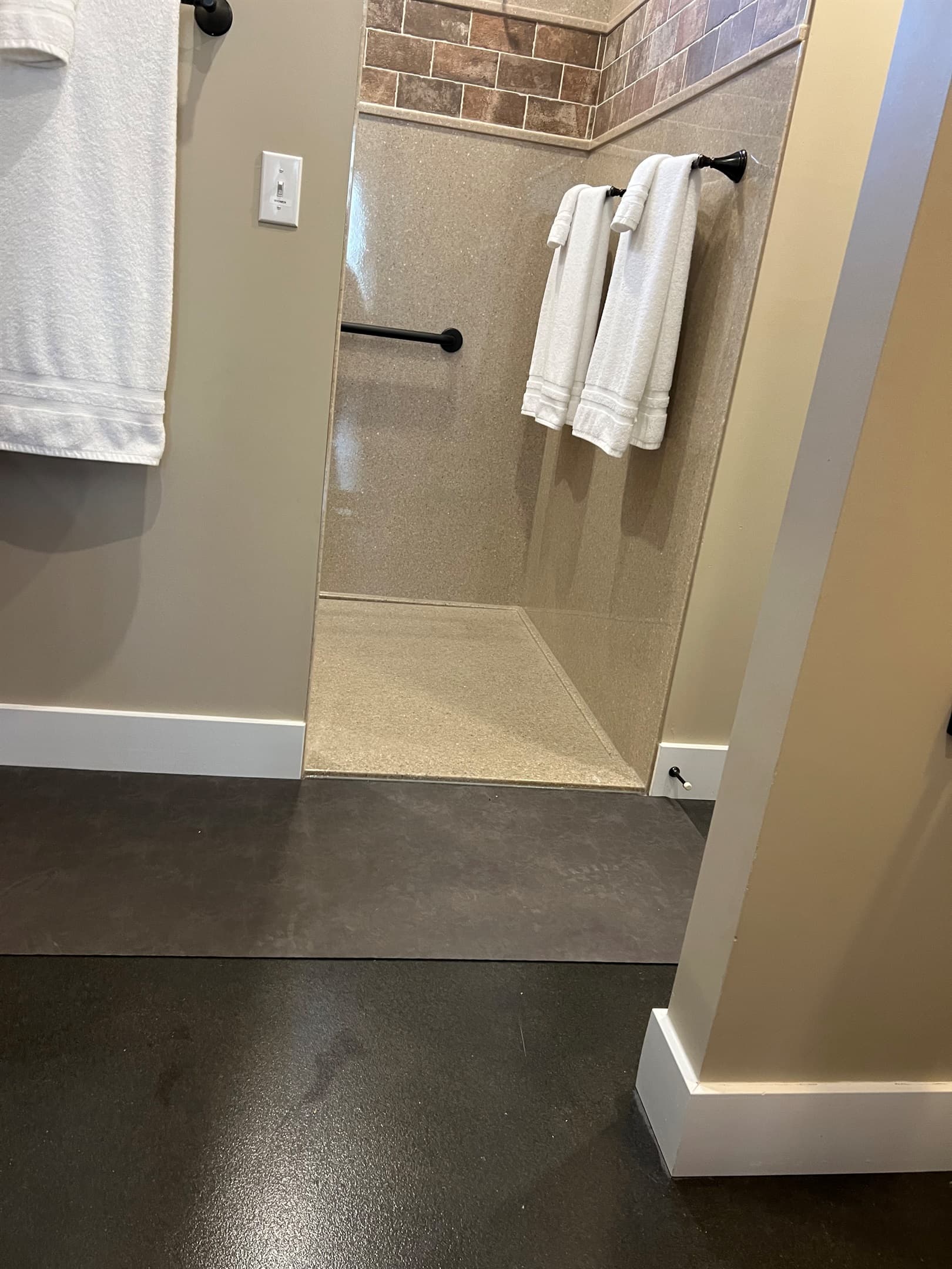 Oversized stand up shower with large bench, grab bars, and handheld shower head and step free access in the Full bathroom at Pikes Peak Schoolhouse.
