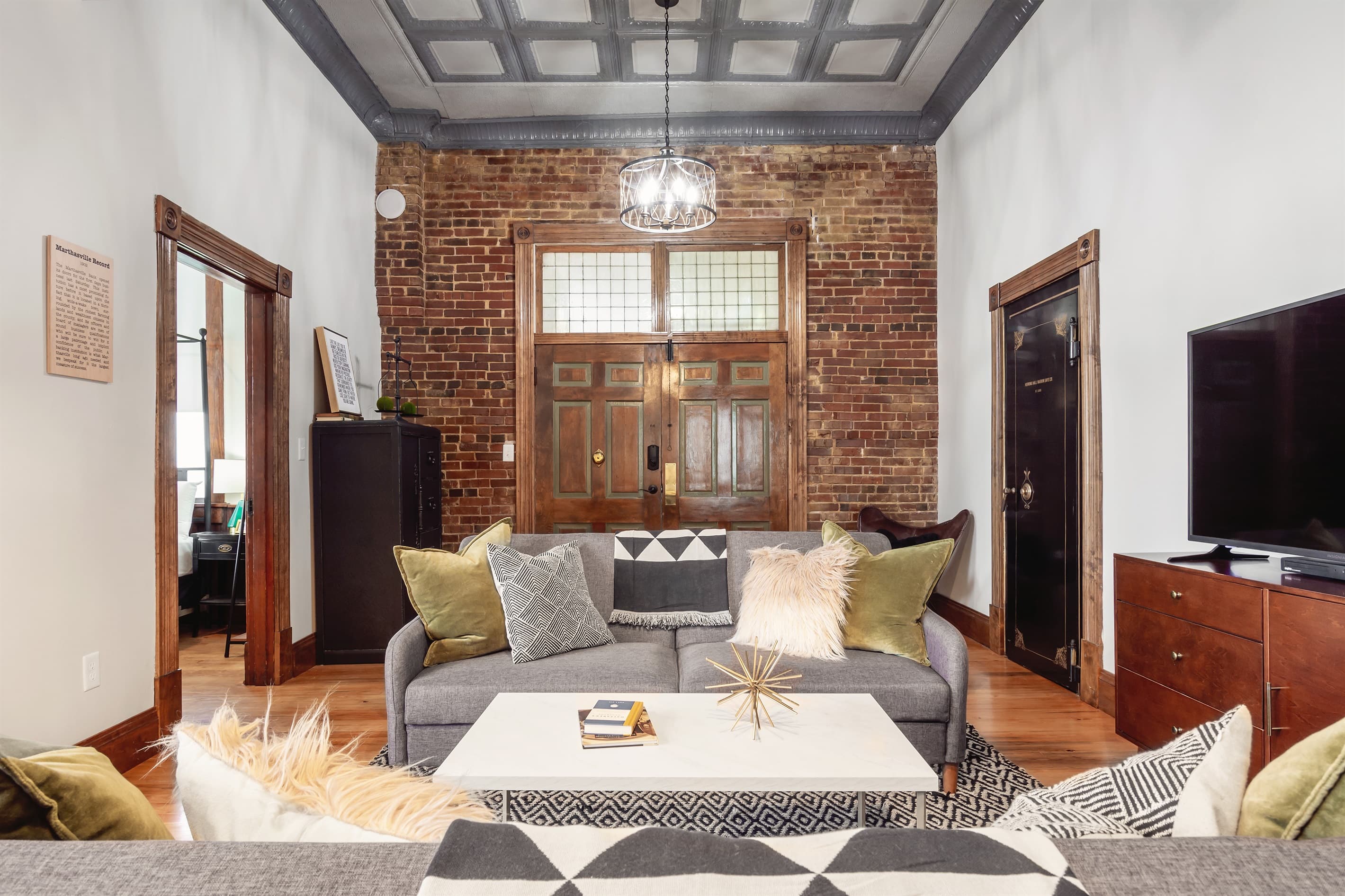 Spacious main level living area with king pull out bed and ample seating at the Bank Haus