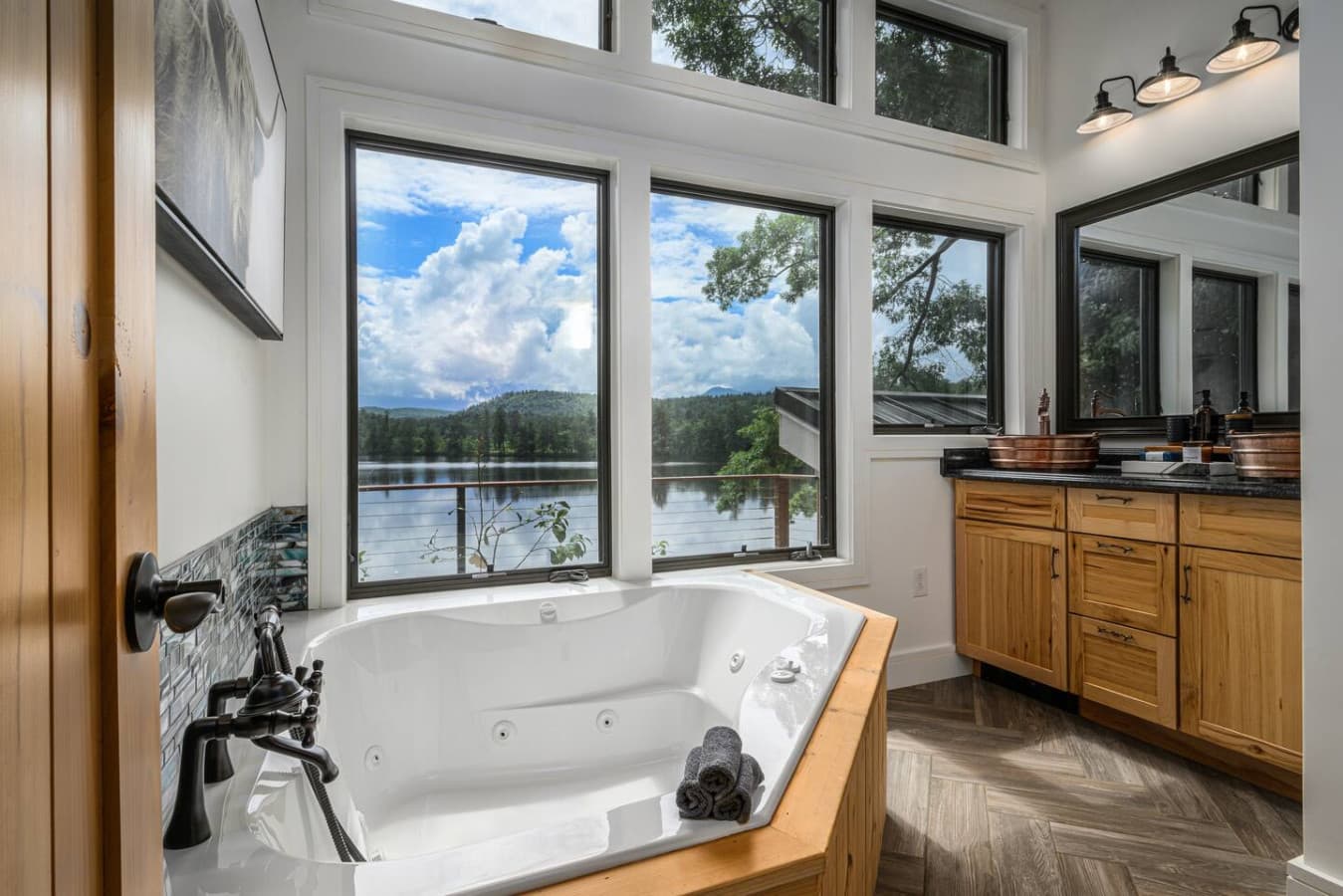 Unwind in a bathroom designed for true relaxation, with a soaking tub, spacious two-person shower, private water closet, chandelier, and stunning views that make this space feel more like a luxury spa than a standard en-suite.