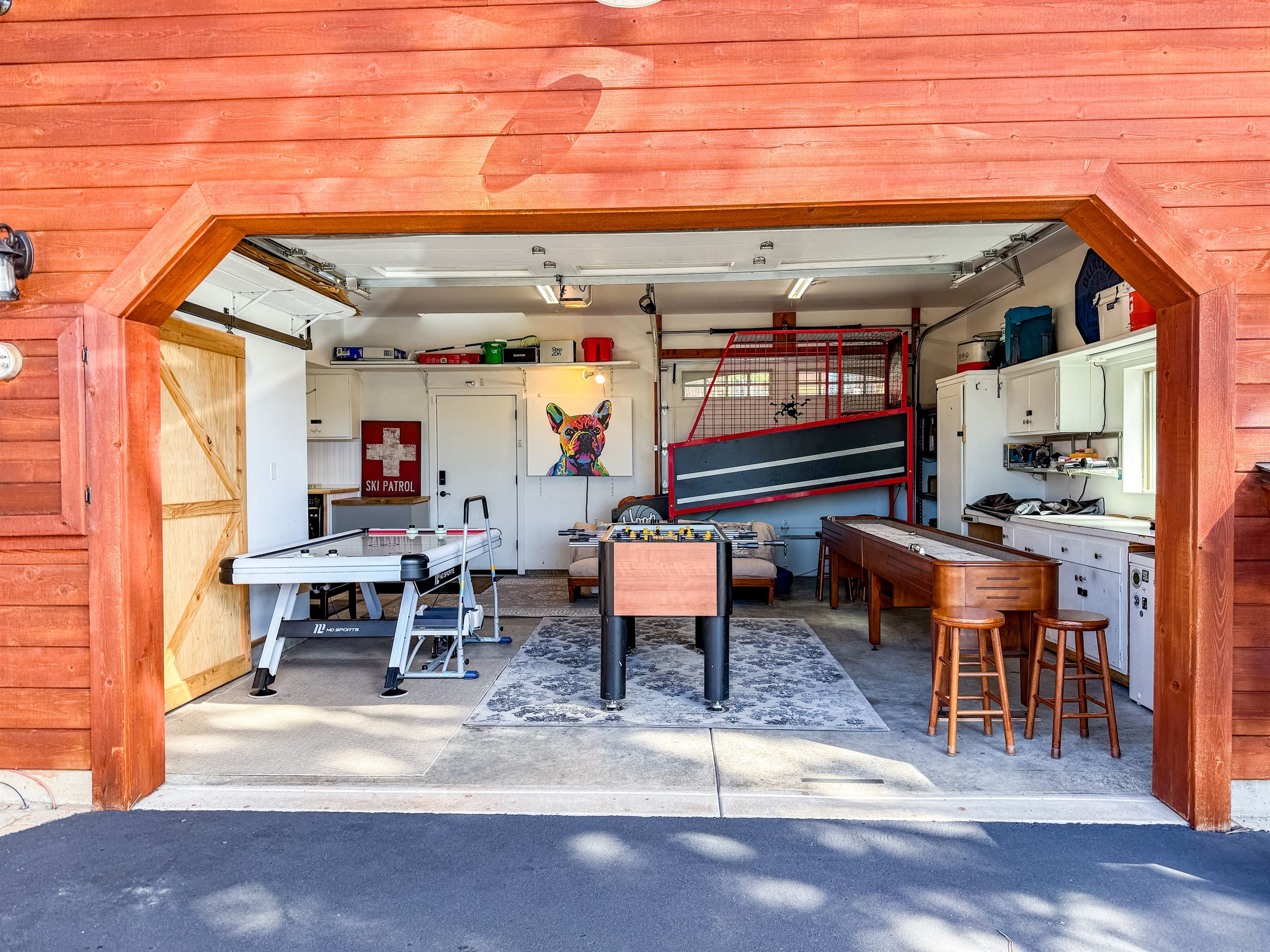 The garage has been transformed into a fun-filled game room featuring Hoop Fever, shuffleboard, air hockey, and foosball. Plus, it's fully heated for year-round enjoyment. In the summer, open up the garage and enjoy the fresh air!
