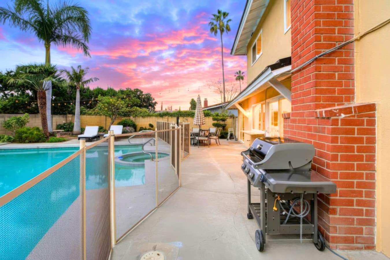 Poolside patio w/ grill & seating, perfect for easy outdoor meals by the water