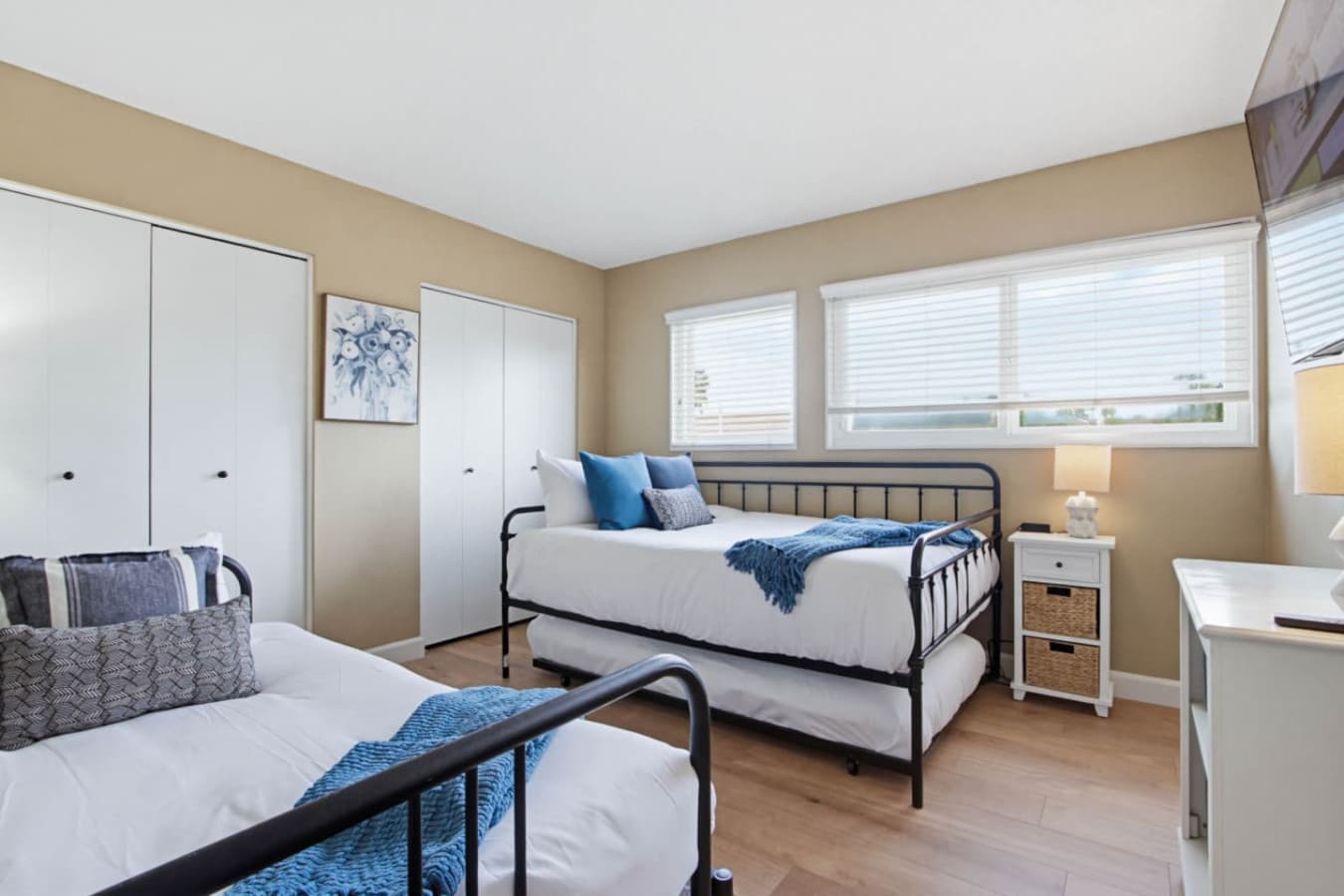 Light-filled bedroom w/ two beds & wide windows creating a calm, airy retreat