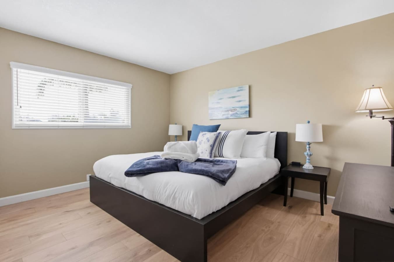 Simple bedroom w/ soft bedding, nightstands & natural light for a comfortable stay