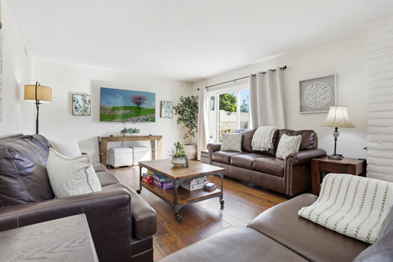 Inviting living room w/ plush seating, fireplace & large windows overlooking greenery