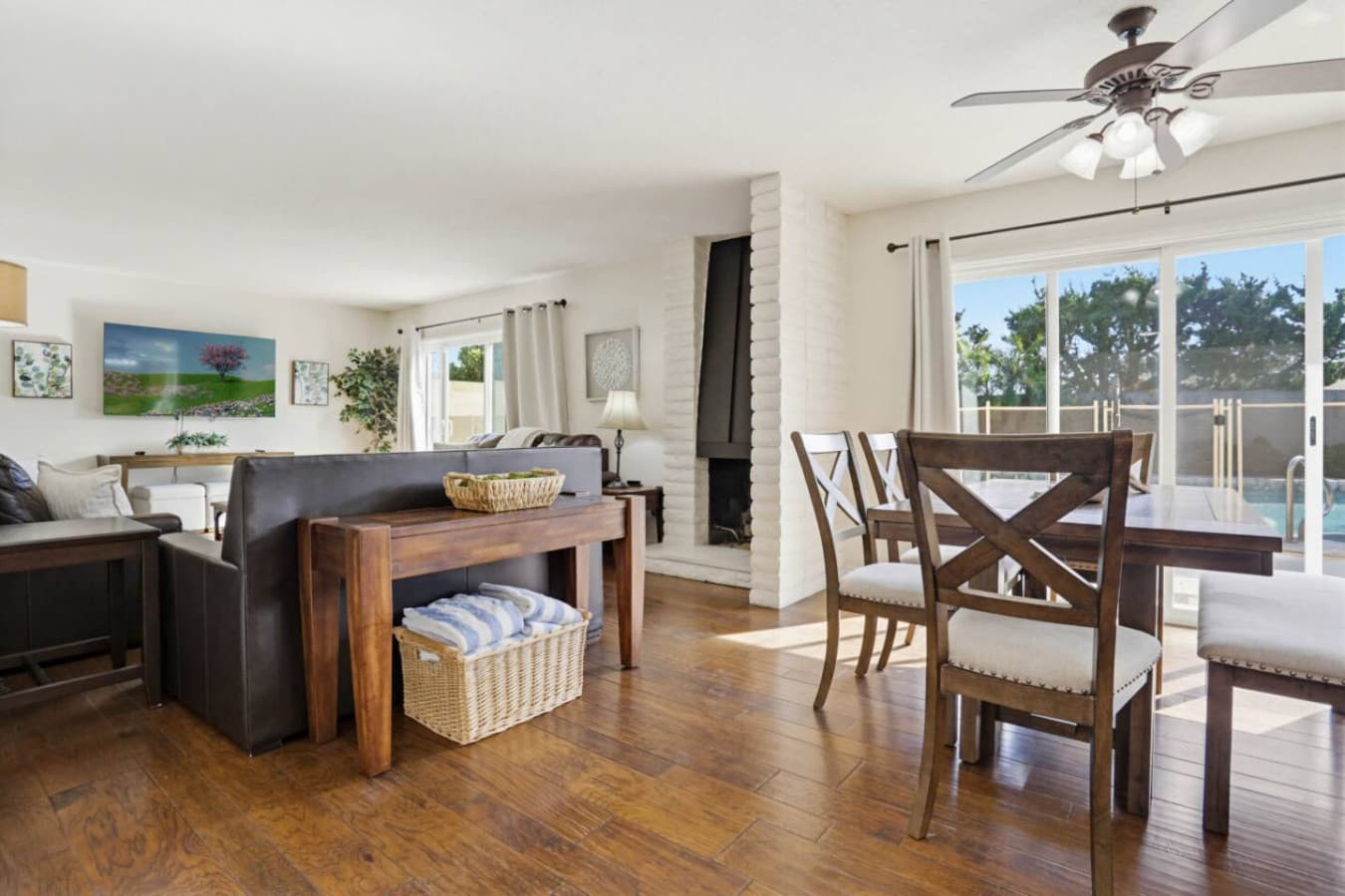 Open living & dining space w/ cozy seating, fireplace & backyard access