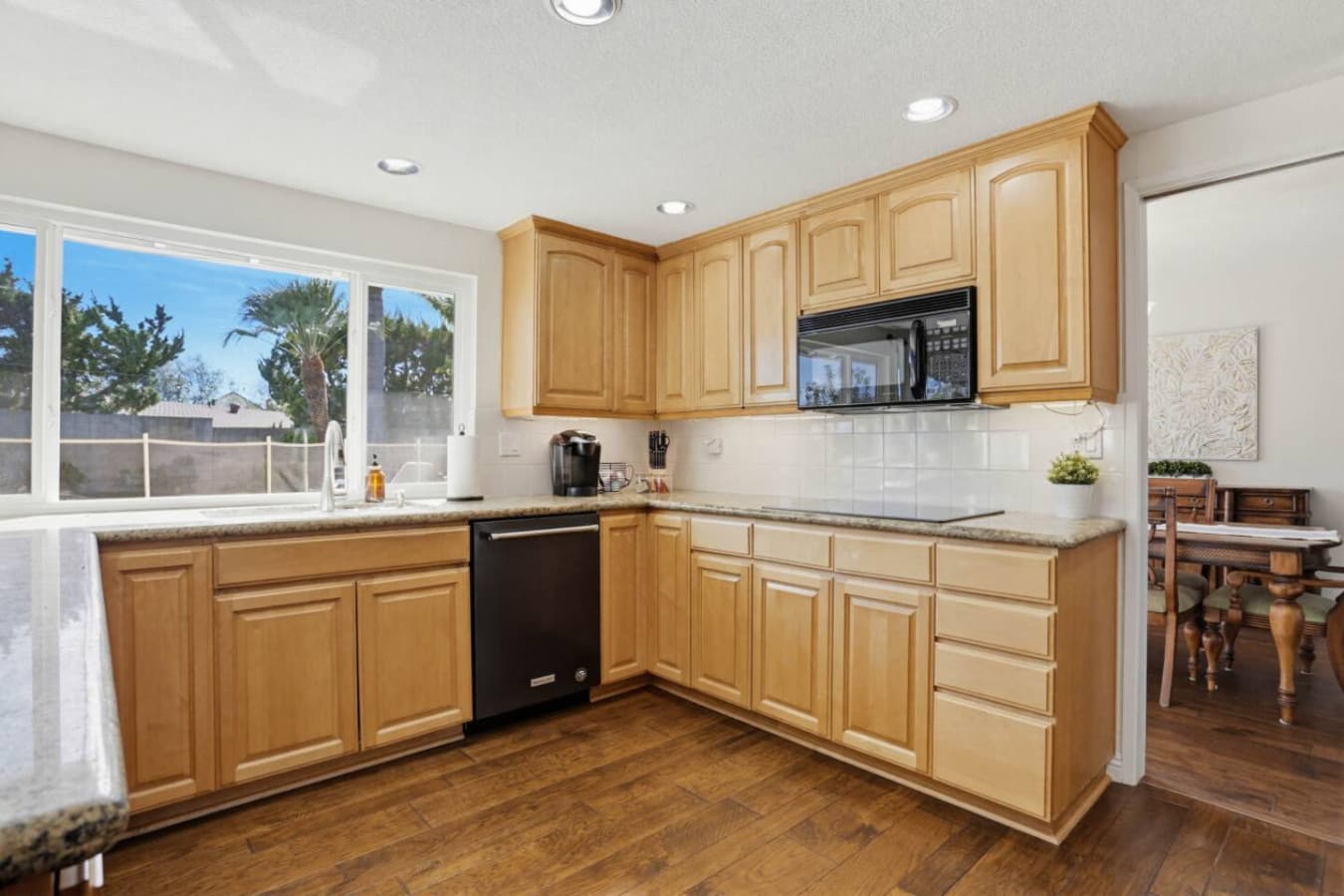 Bright kitchen w/ wood cabinets, large window & plenty of counter space for easy prep