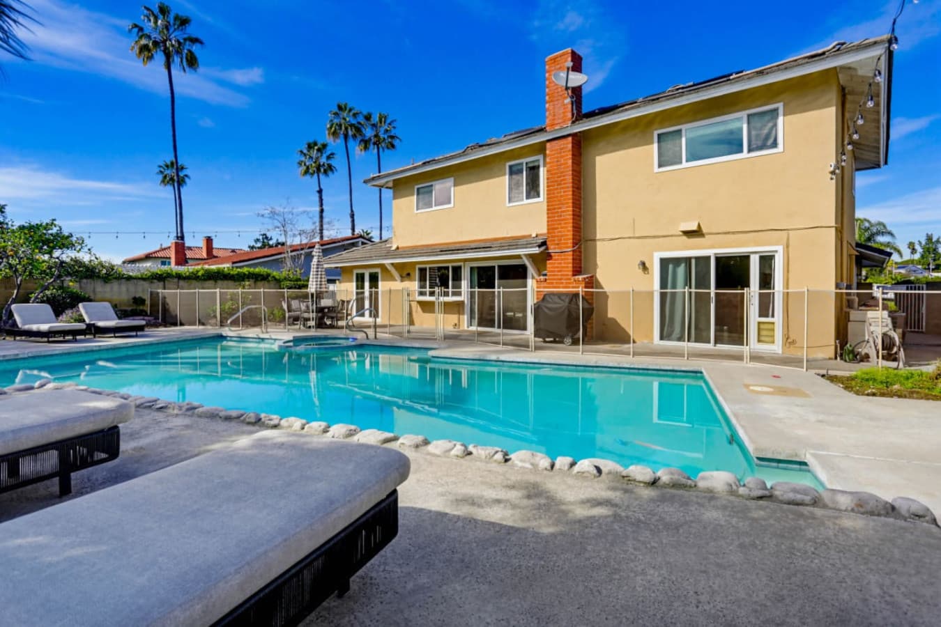 Backyard pool w/ lounge seating & spacious patio, perfect for sunny days outdoors