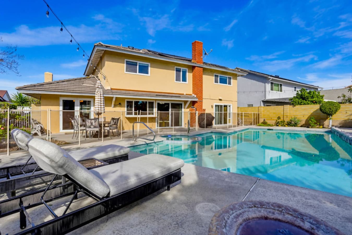 Private pool area w/ cushioned loungers & shaded seating for relaxing afternoons