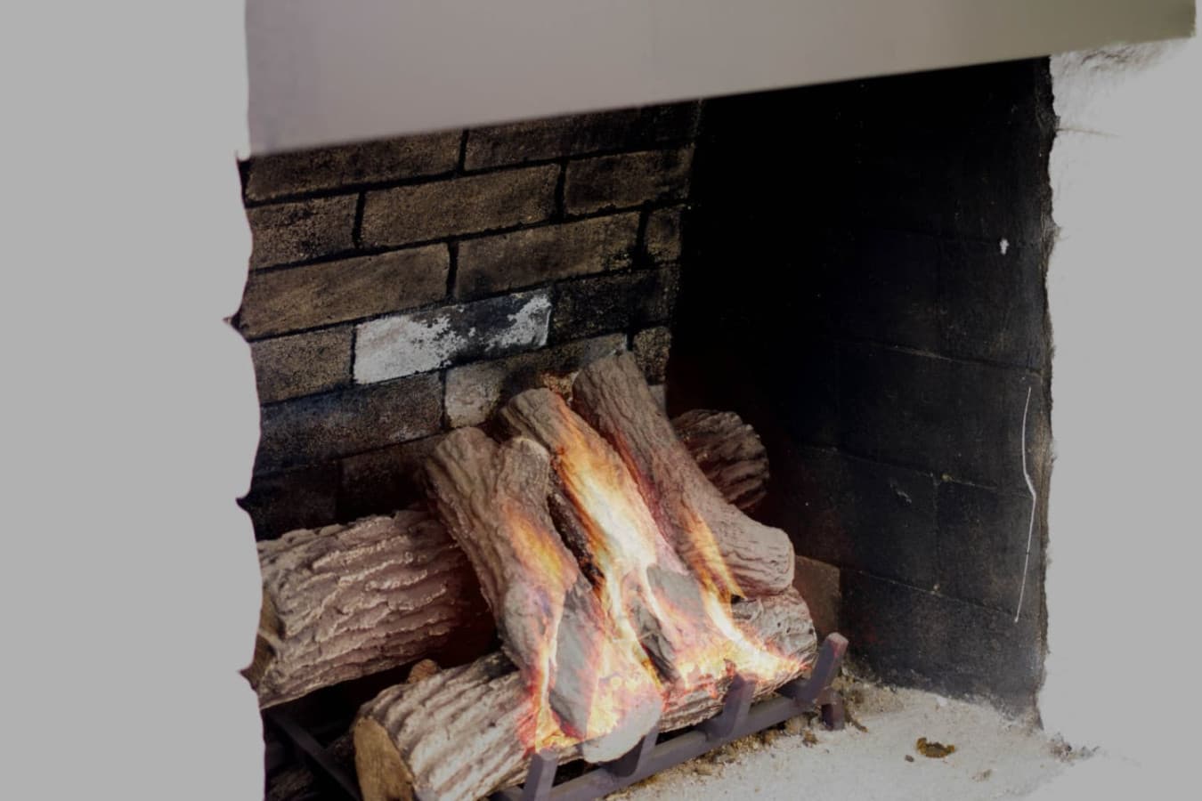 Close-up fireplace w/ glowing logs, adding warmth & cozy ambiance indoors