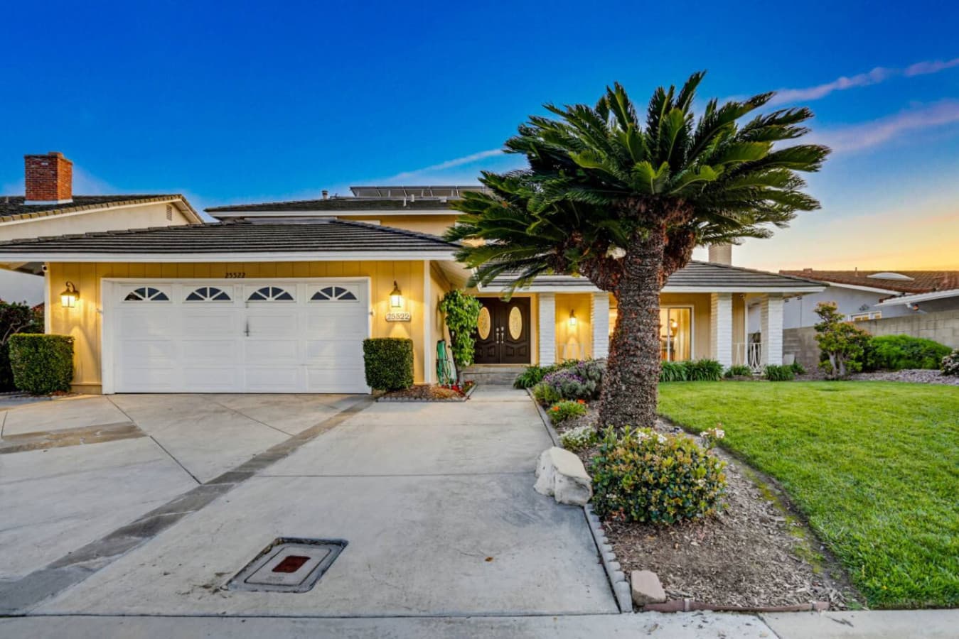 Front exterior w/ driveway, garage & palm tree for a welcoming arrival
