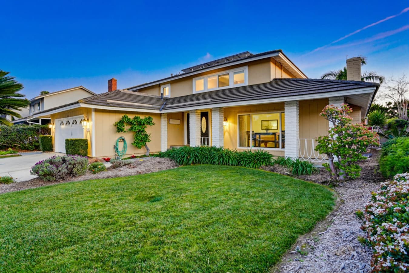 Charming front exterior w/ lush lawn, covered entry & welcoming curb appeal
