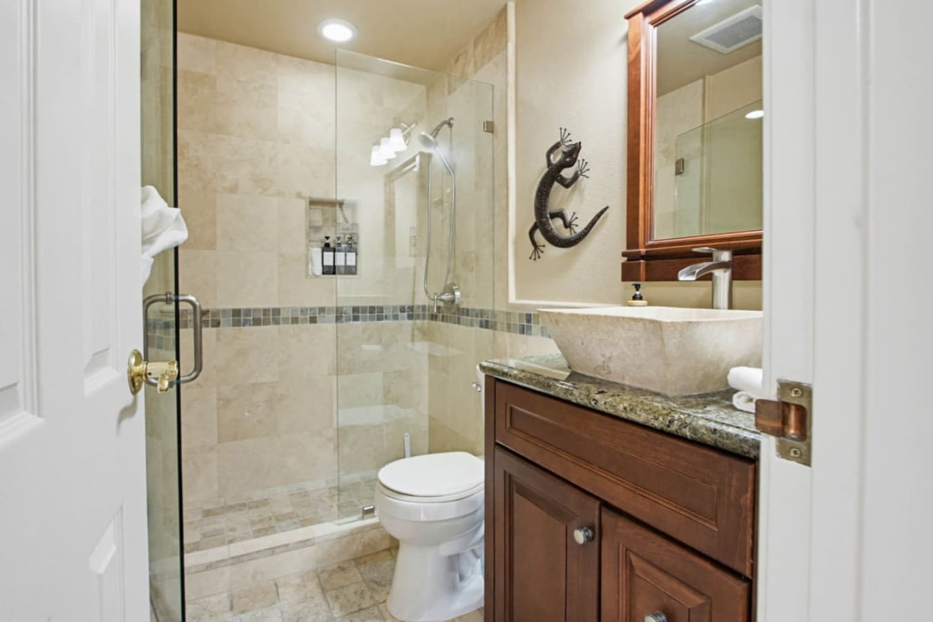 Bathroom w/ vanity, shower & tiled finishes for a clean, comfortable space
