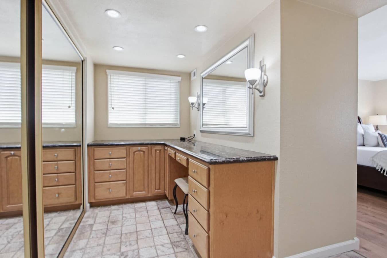 Dressing area w/ built-in vanity, mirrored closet doors & window light for getting ready.
