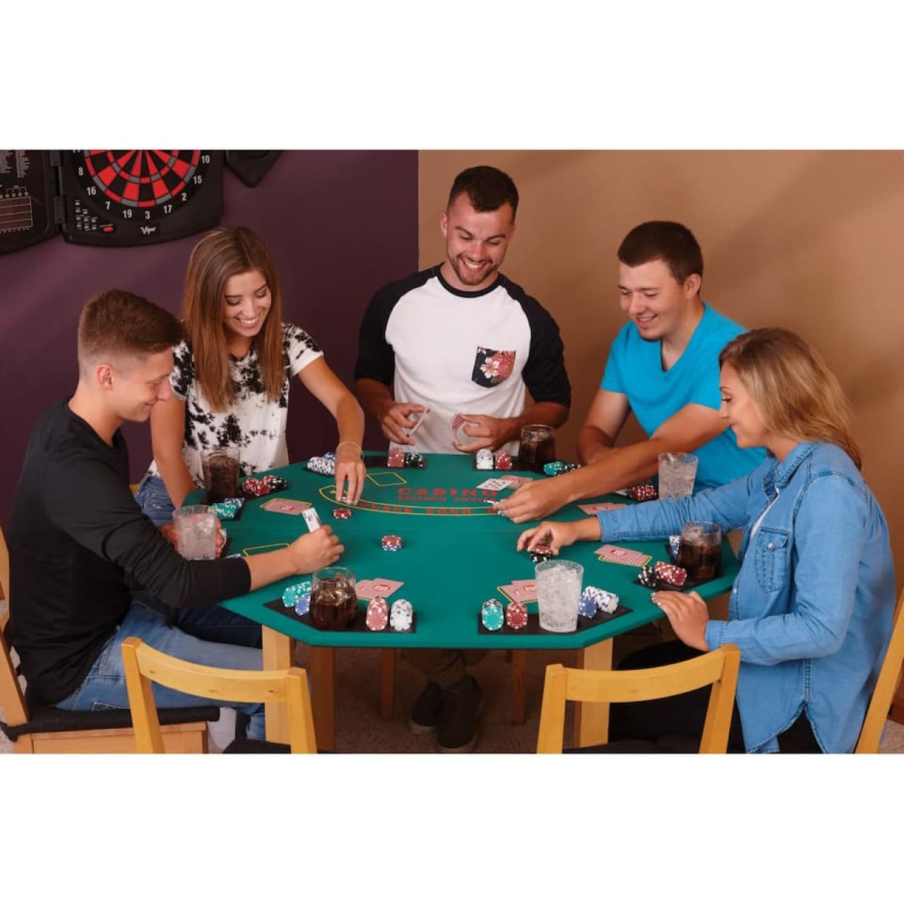 Game night setup w/ a felt poker table, chips & a wall dartboard for group competition.