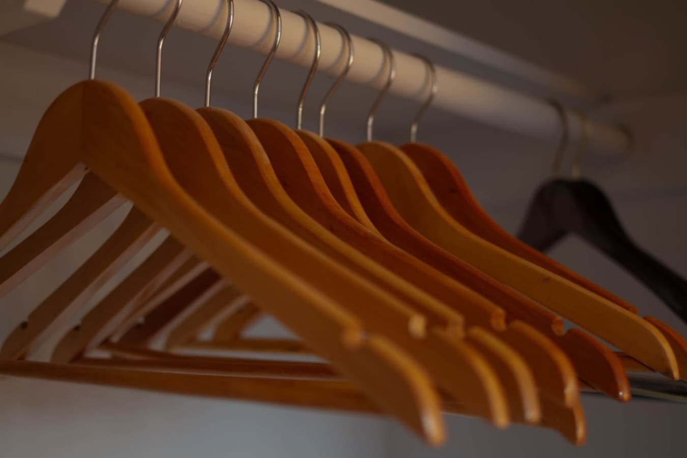Closet detail w/ a row of wooden hangers, ready for unpacking on longer stays.