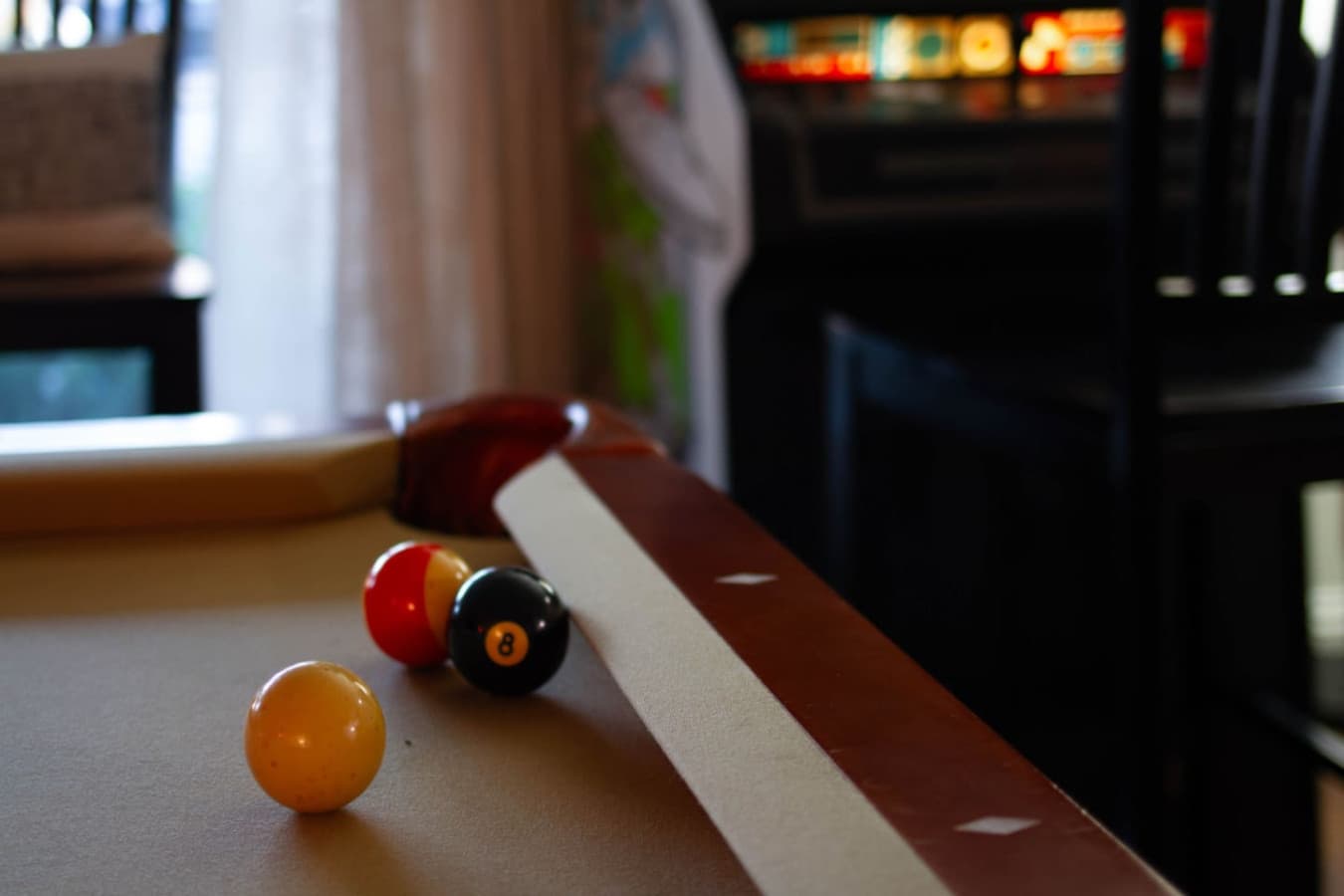 Pool table detail w/ balls on the felt for a few casual games indoors.