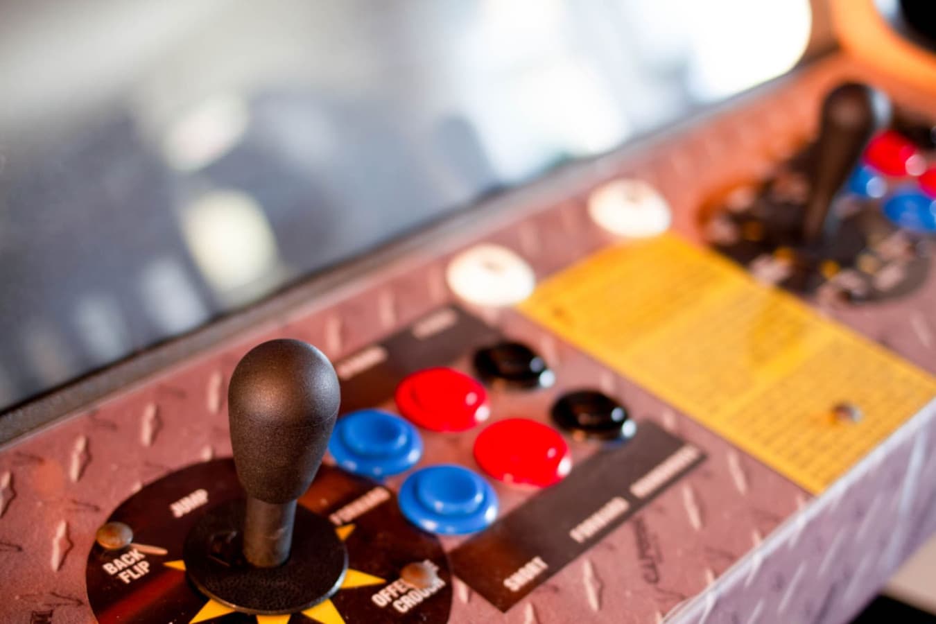 Arcade cabinet detail w/ joystick & buttons for retro game sessions at home.