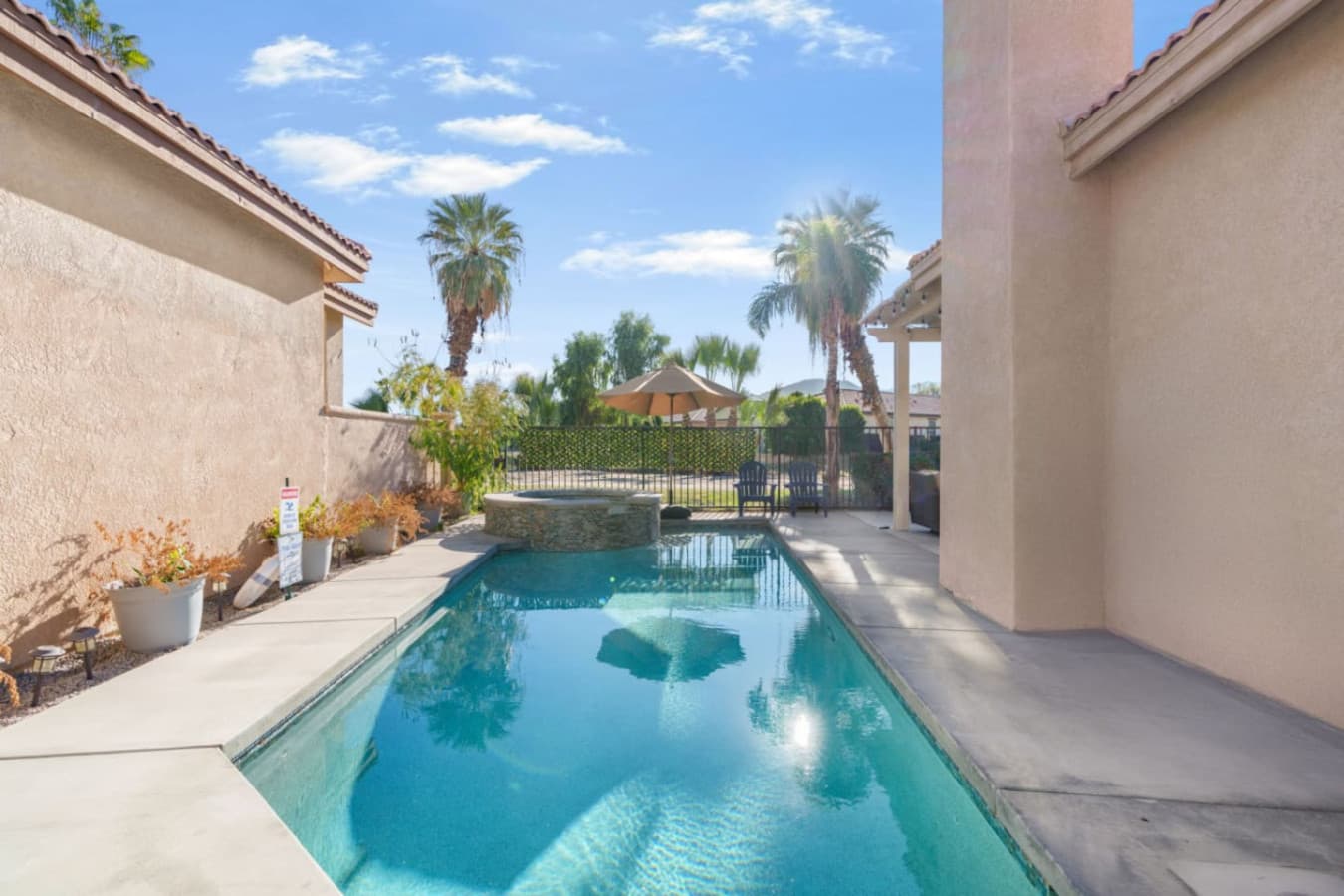 Sunlit private pool framed by desert landscaping, perfect for a refreshing dip and laid-back outdoor lounging.