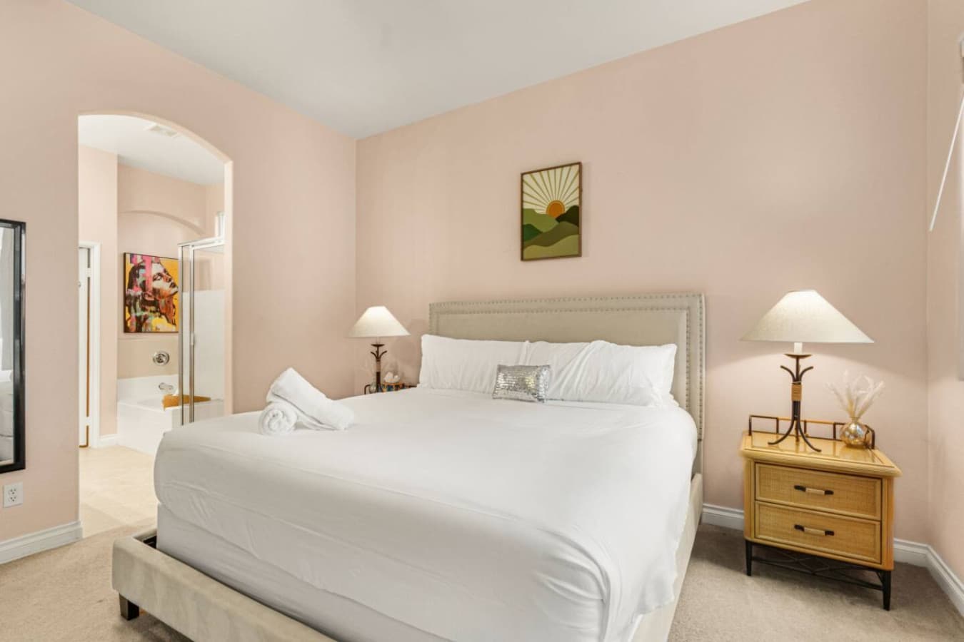 Inviting bedroom w/ matching nightstands, warm lamps, and a calm atmosphere to fully unwind.