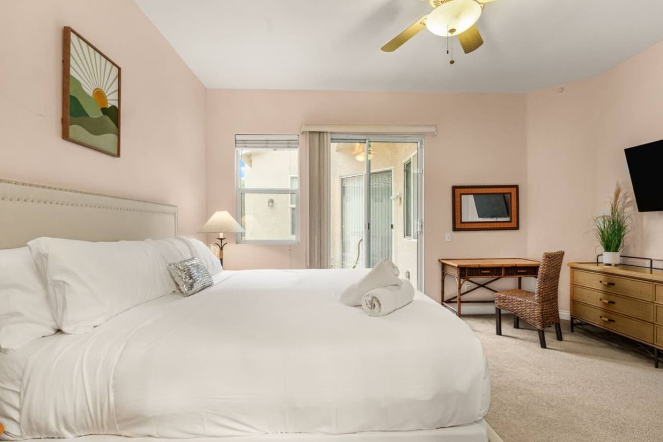 Spacious bedroom angle w/ seating area and bright windows, blending comfort and everyday functionality.